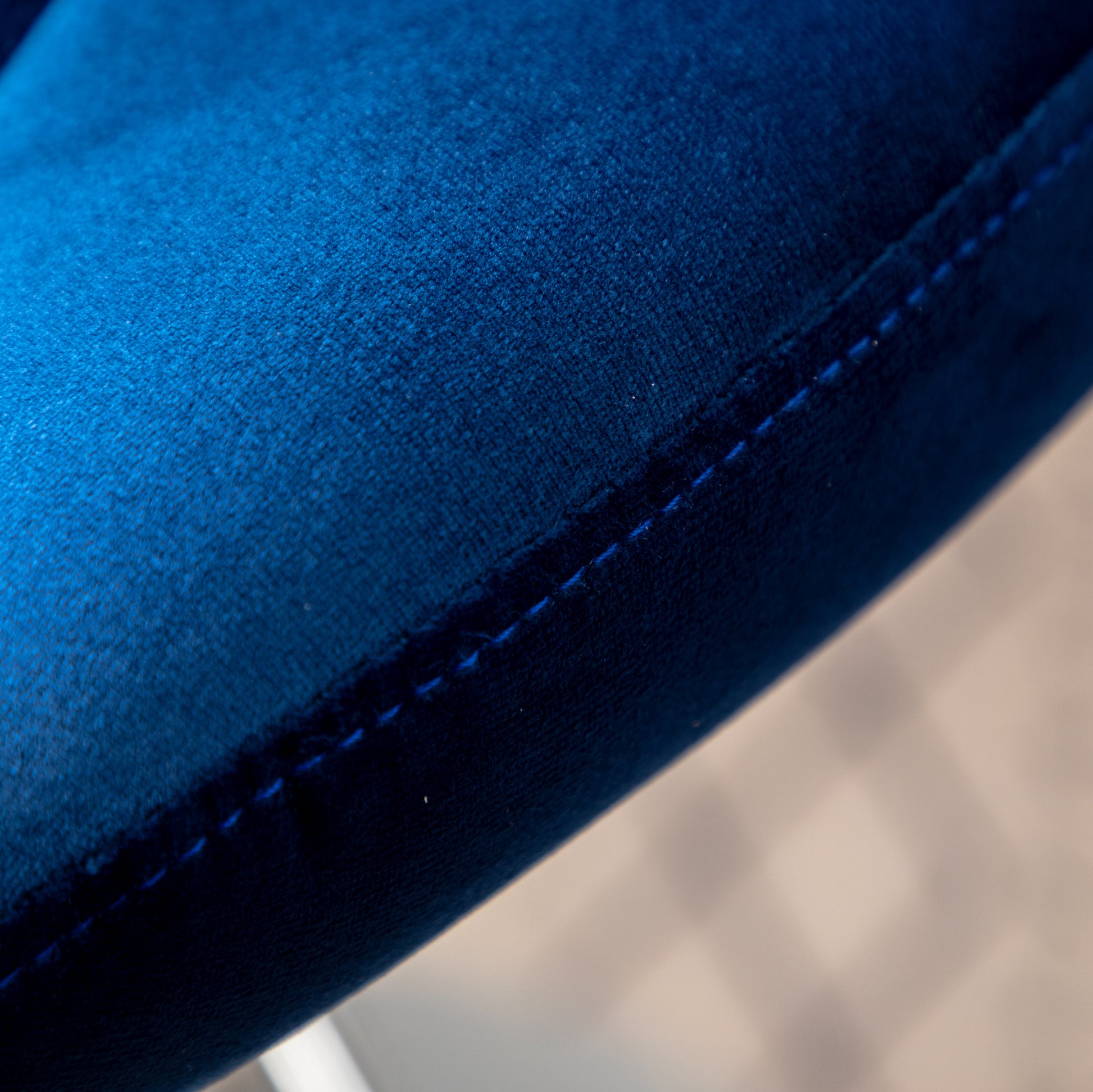 Closeup of plush navy blue velvet fabric with subtle stitching detail