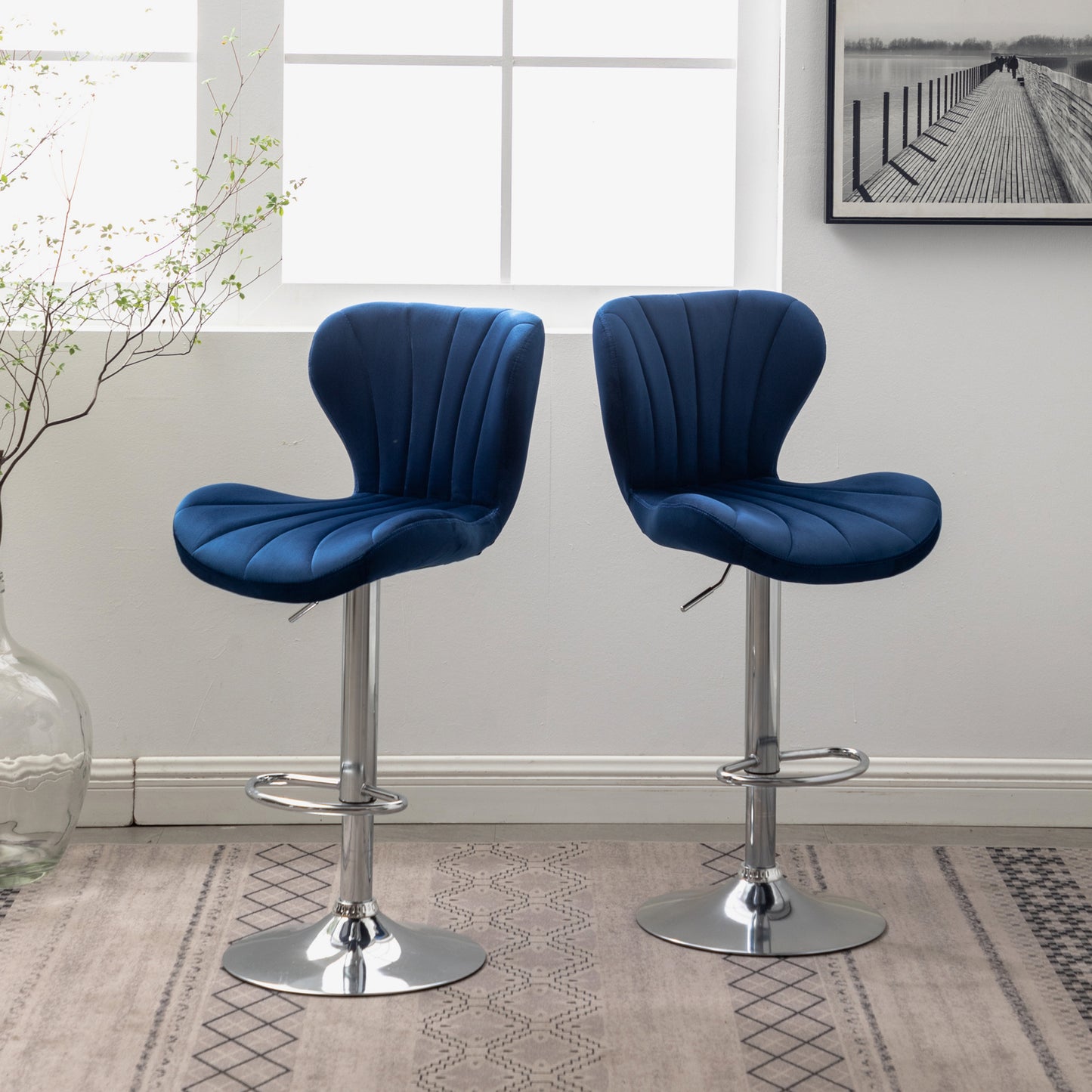 Pair of plush navy blue velvet bar stools with chrome bases and adjustable height