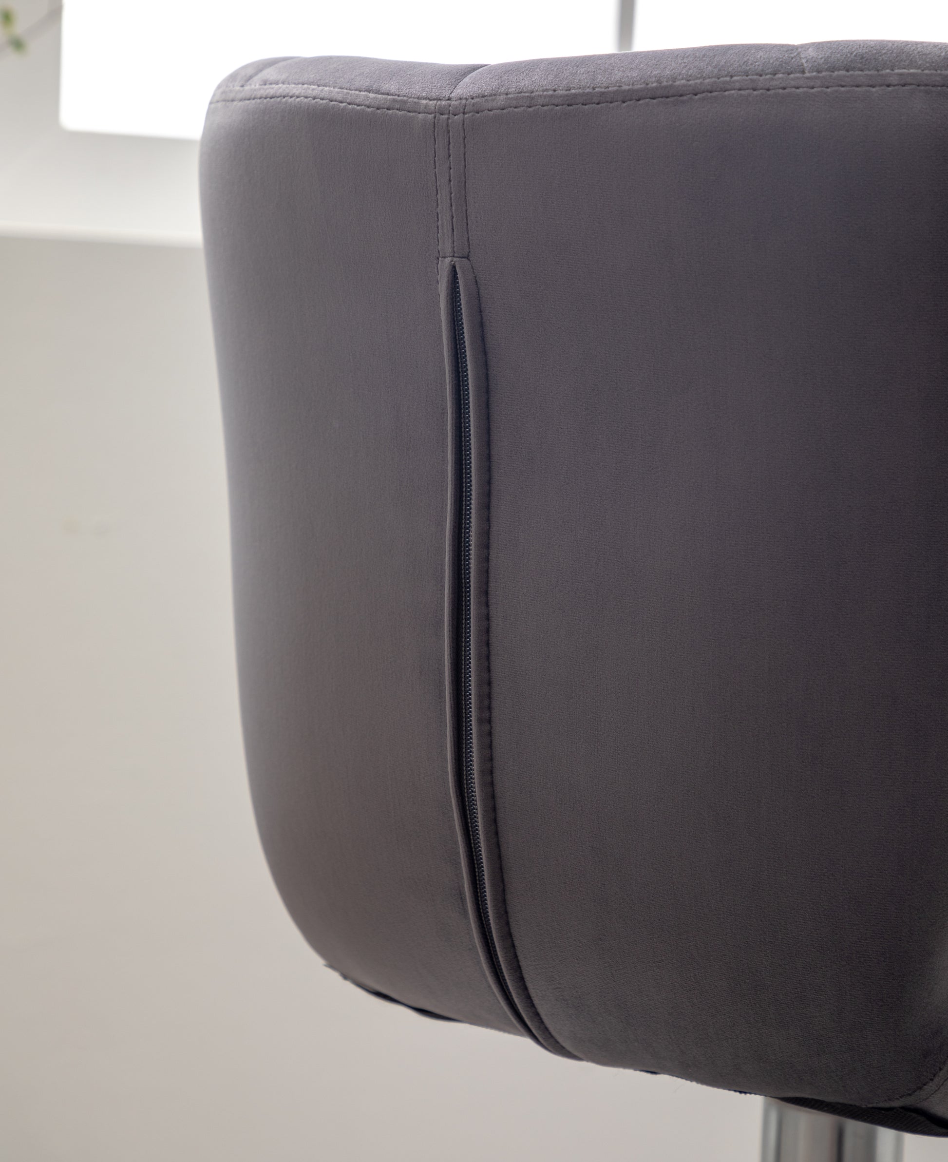 Dark gray velvet bar stool back with prominent stitching detail