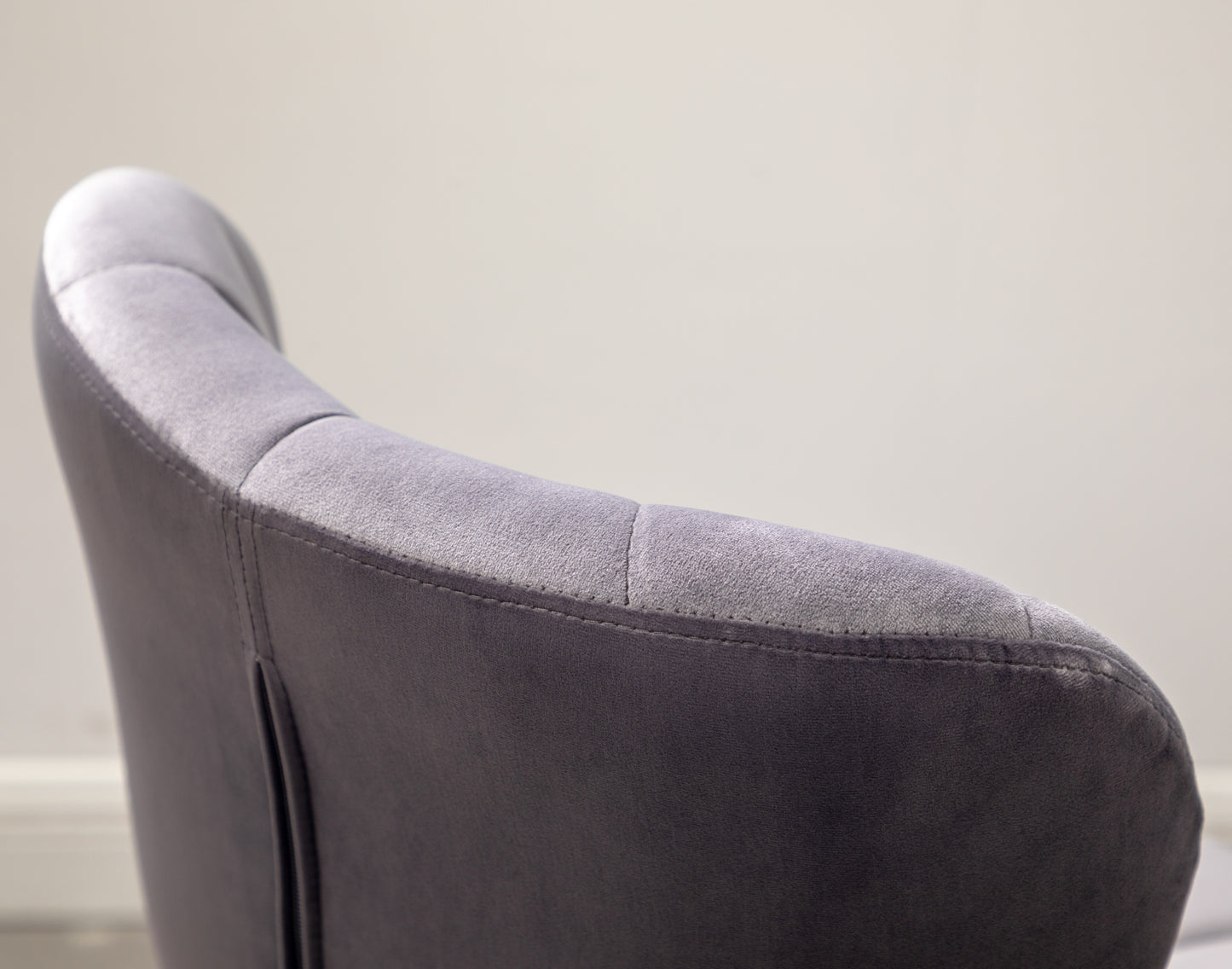 Close up of a plush grey velvet armchair back