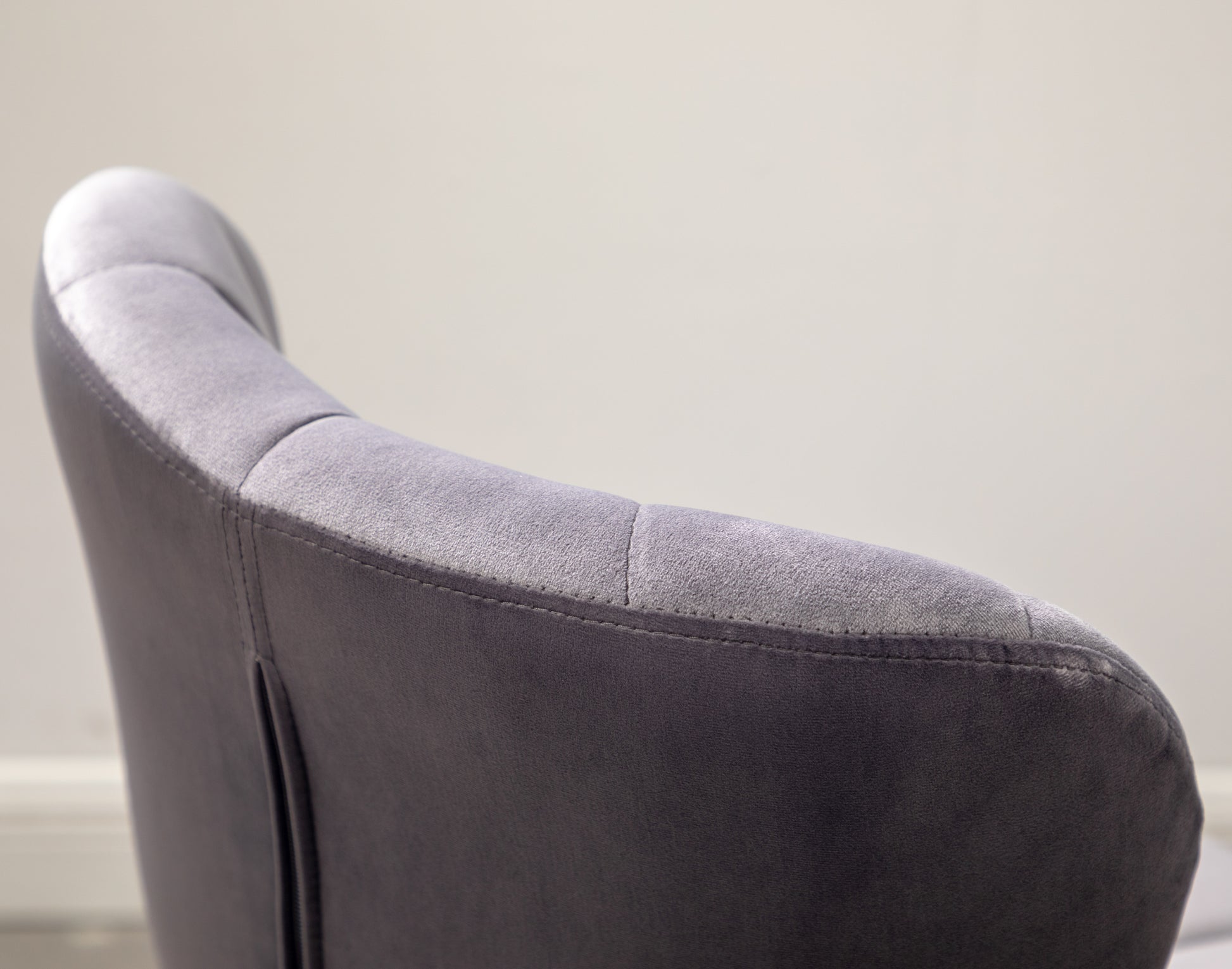 Close up of a plush grey velvet armchair back