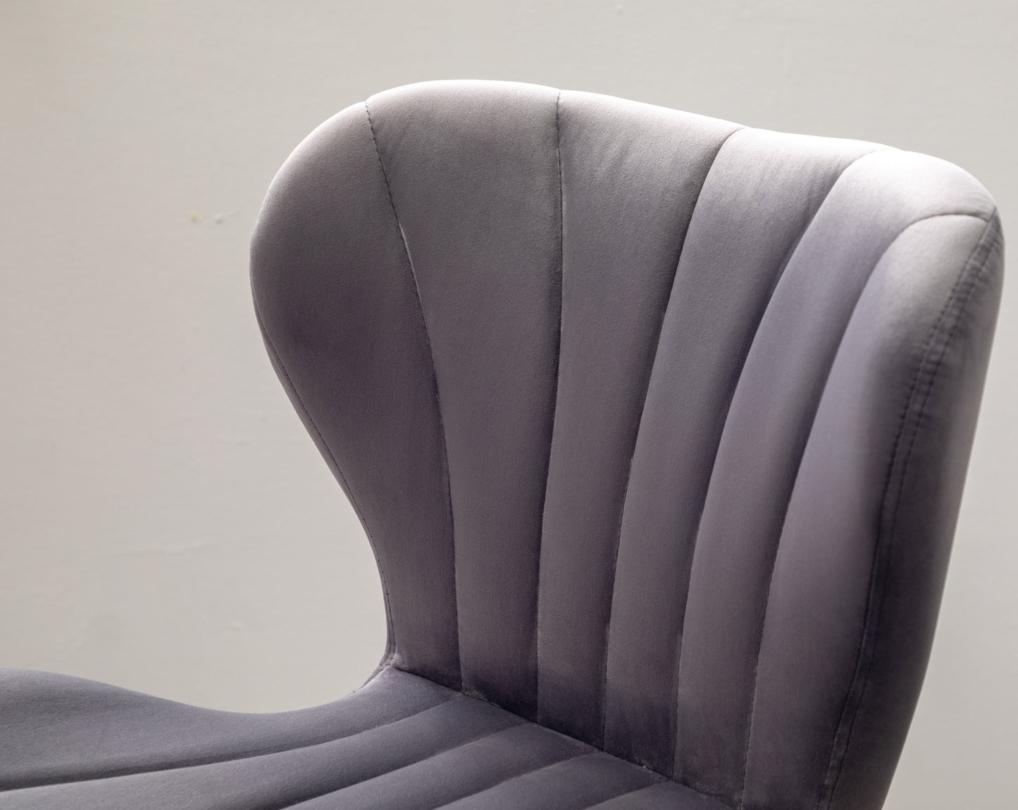 Grey velvet accent chair with channel tufting on the back
