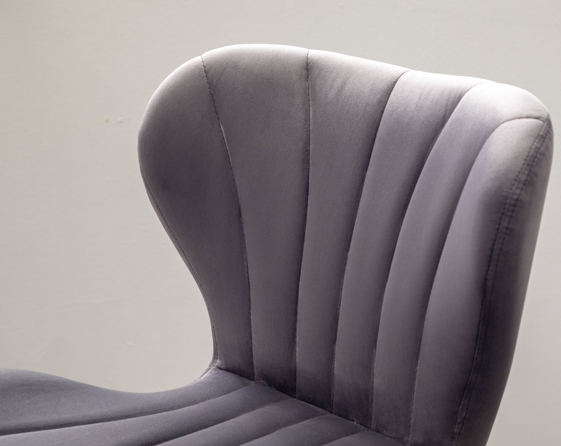 Grey velvet accent chair with channel tufting on the back