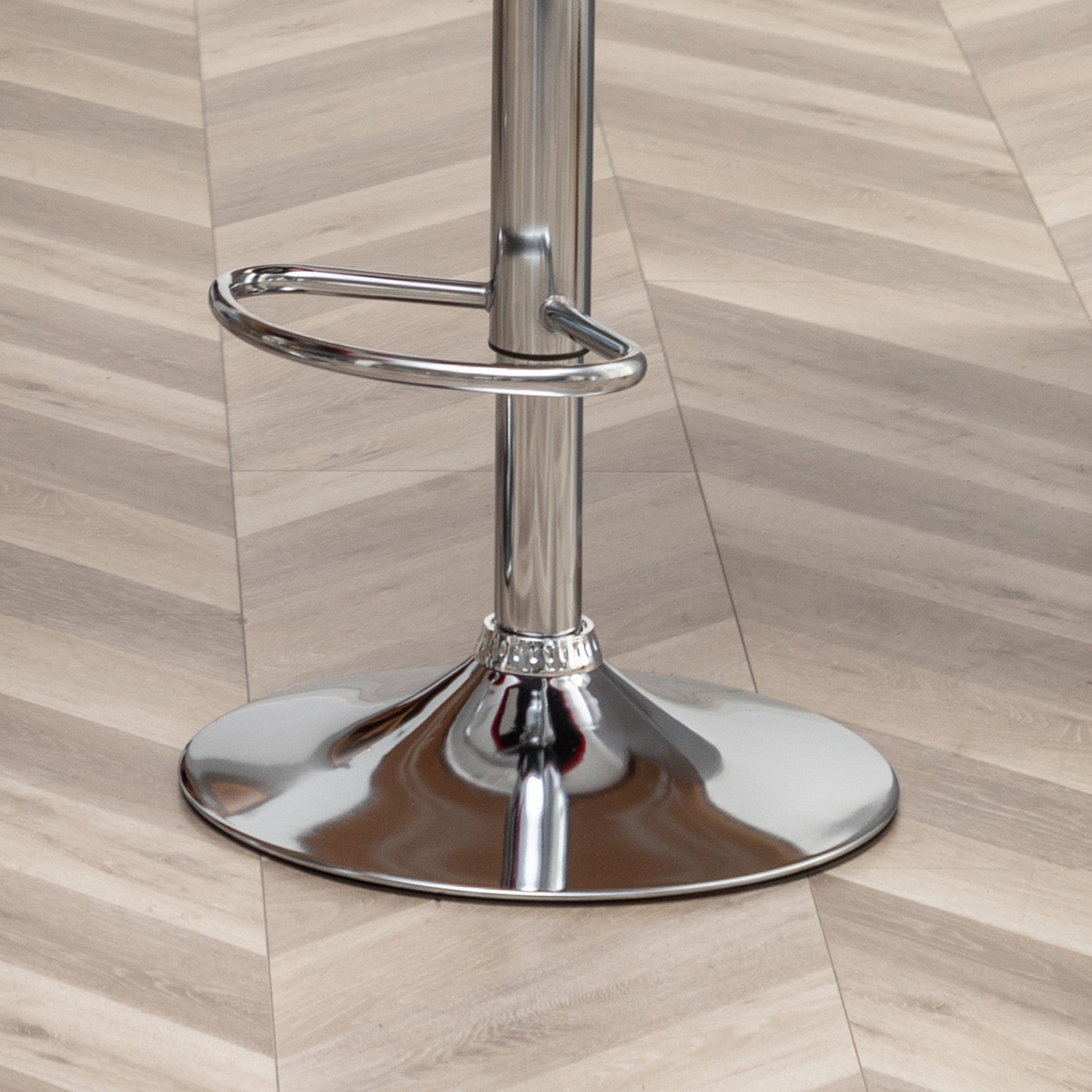 Chrome bar stool base with footrest ring on woodlook floor