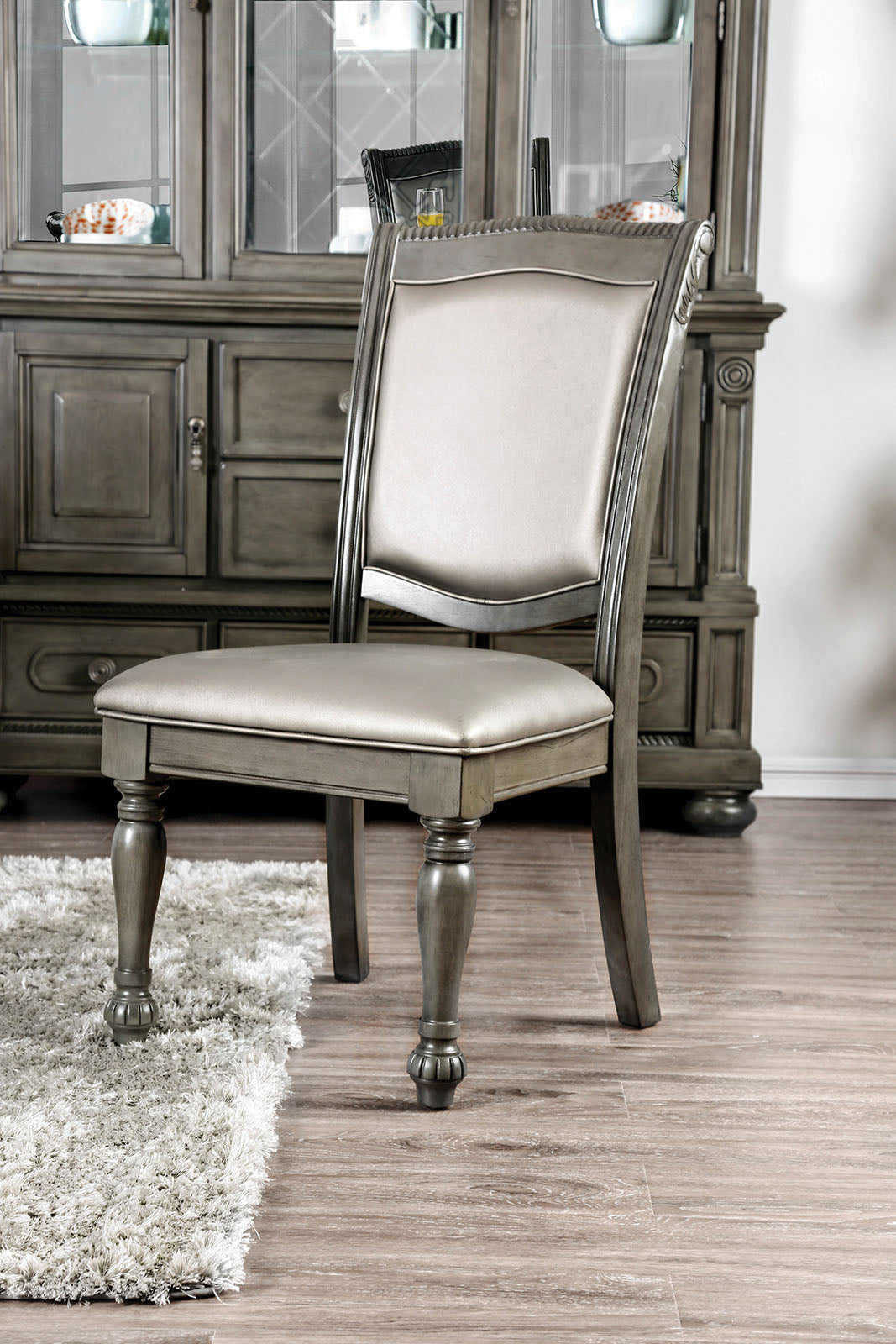 Gray upholstered dining chair with carved wood legs