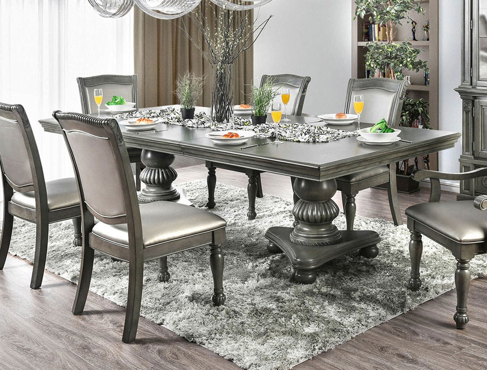 Elegant grey dining table with carved pedestal base and tufted chairs