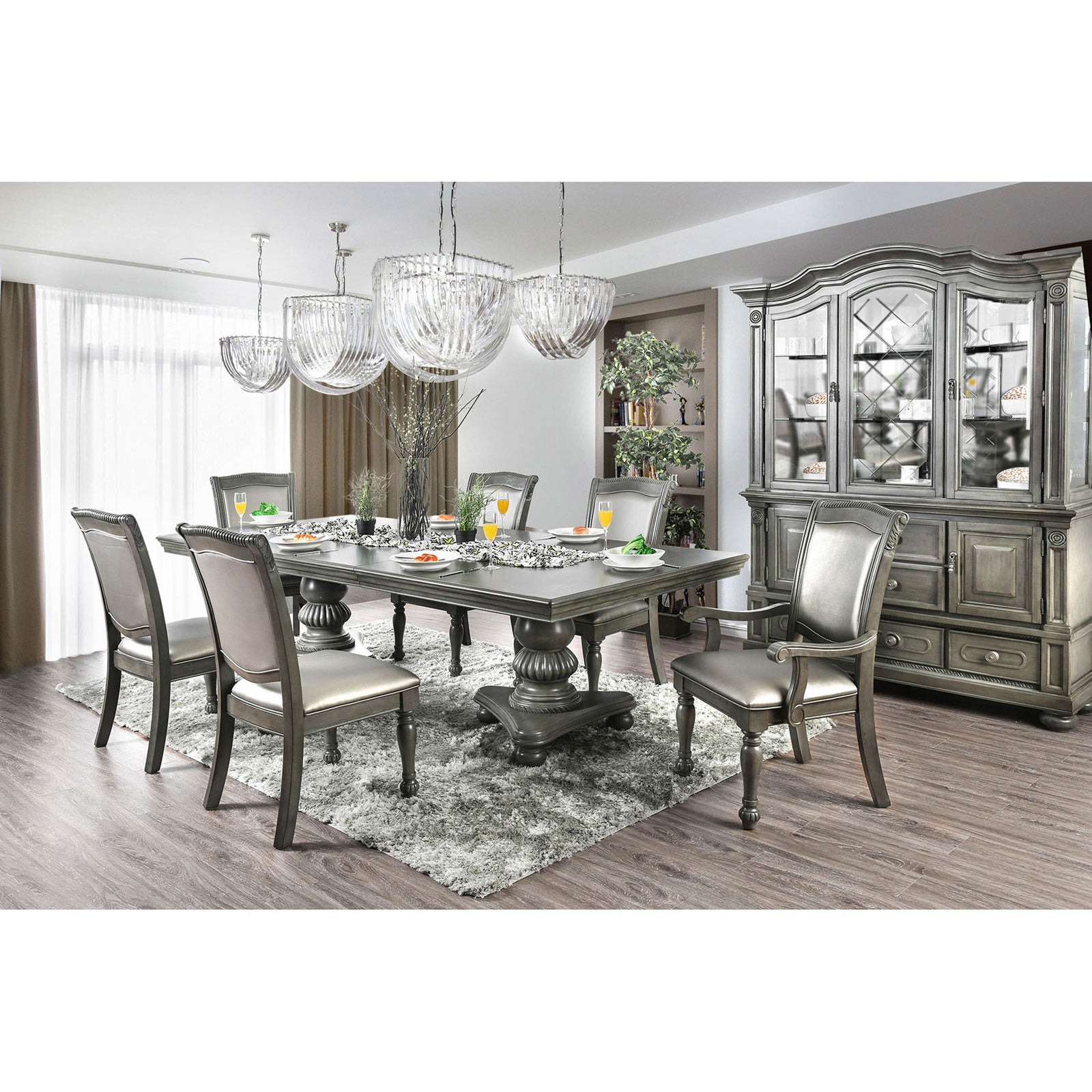 Gray upholstered dining chairs surrounding a pedestal table