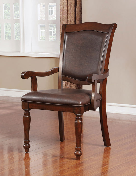 Dark brown leather armchair with carved wooden legs and arms