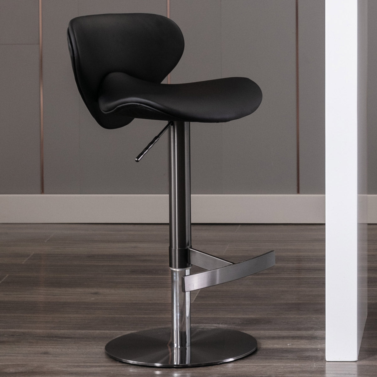 Sleek black leather adjustable bar stool with chrome base and footrest