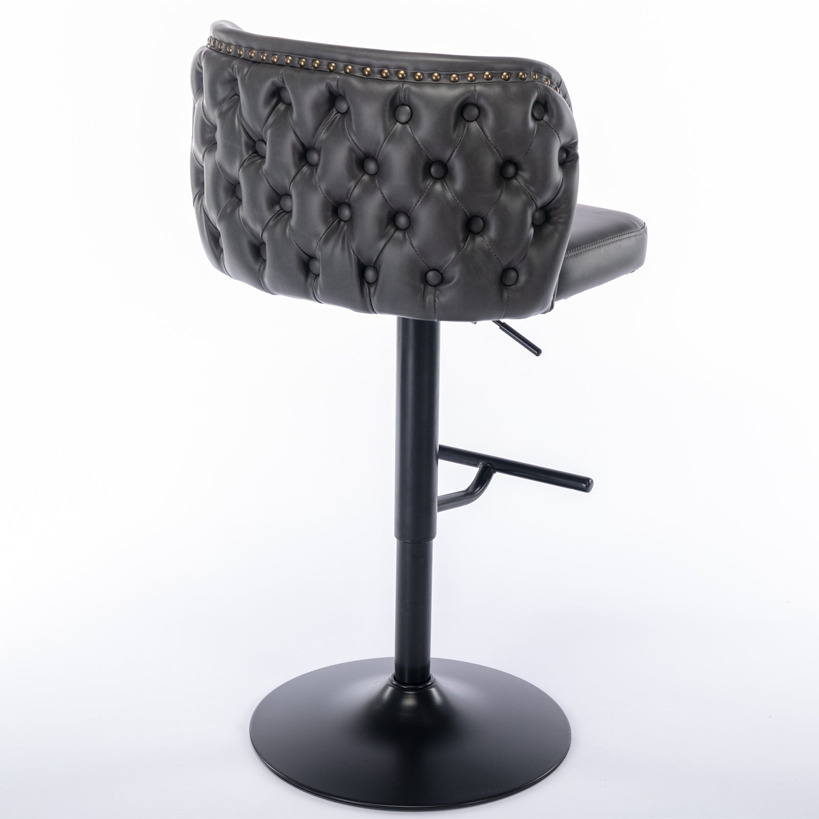 Dark grey tufted faux leather bar stool with brass nailhead trim and black metal base