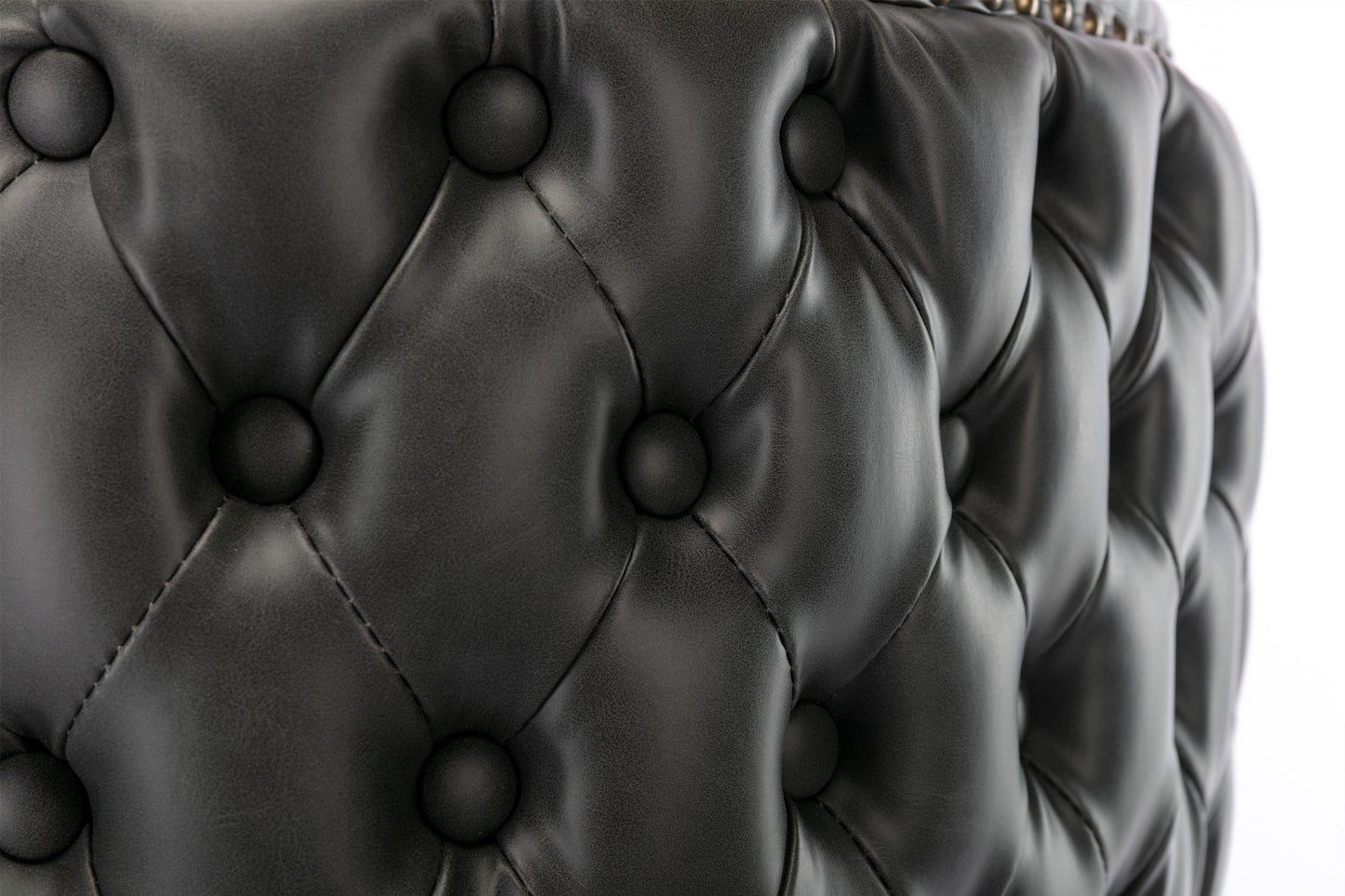 Closeup of tufted black faux leather upholstery on a chair