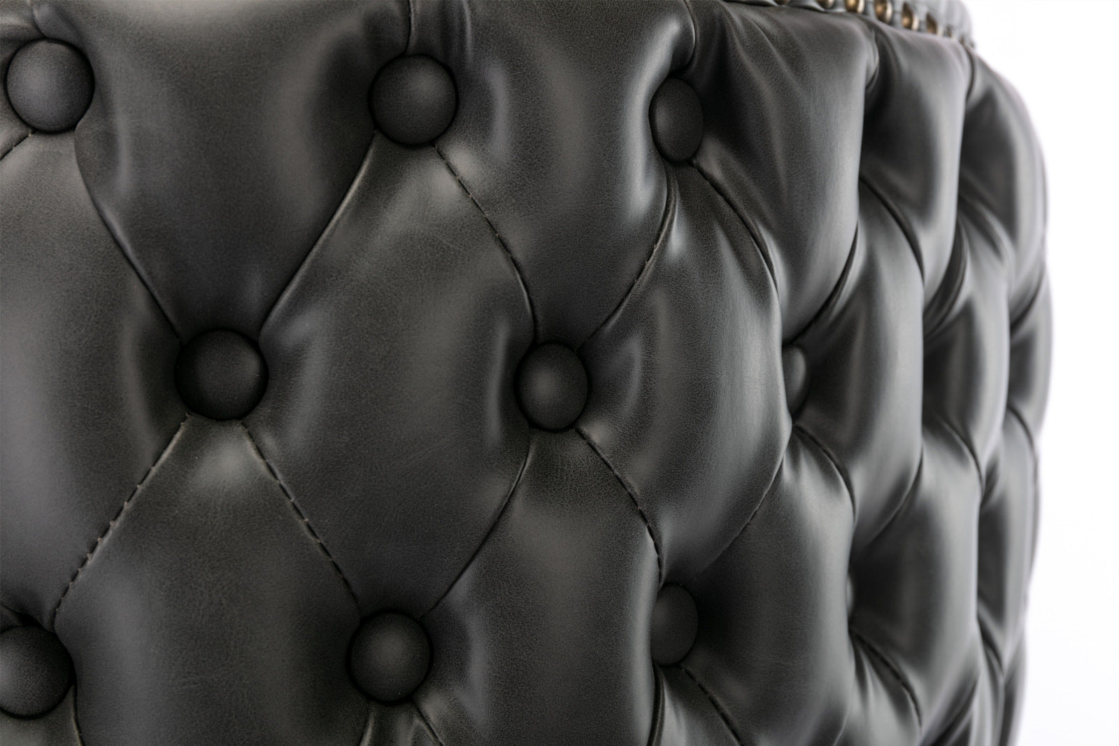 Closeup of tufted black faux leather upholstery on a chair