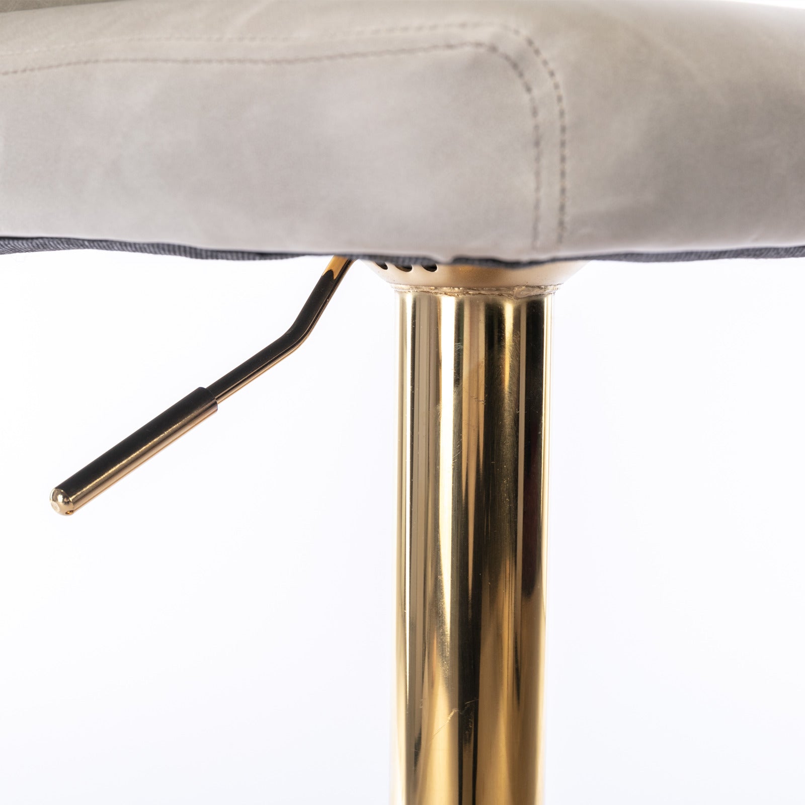 Close up of a grey upholstered bar stool seat with a gold adjustable lever