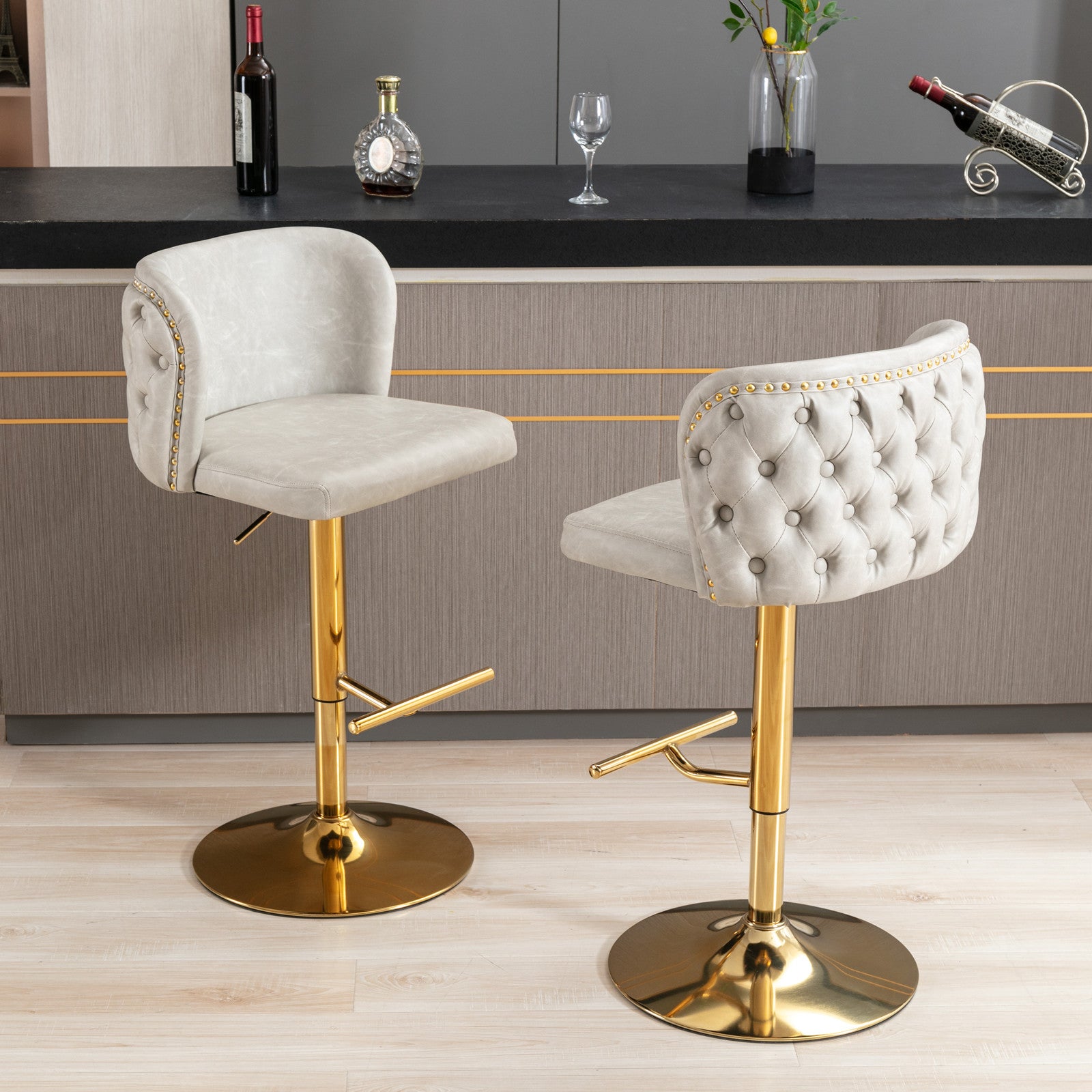 Light gray tufted bar stool with gold base and nailhead trim