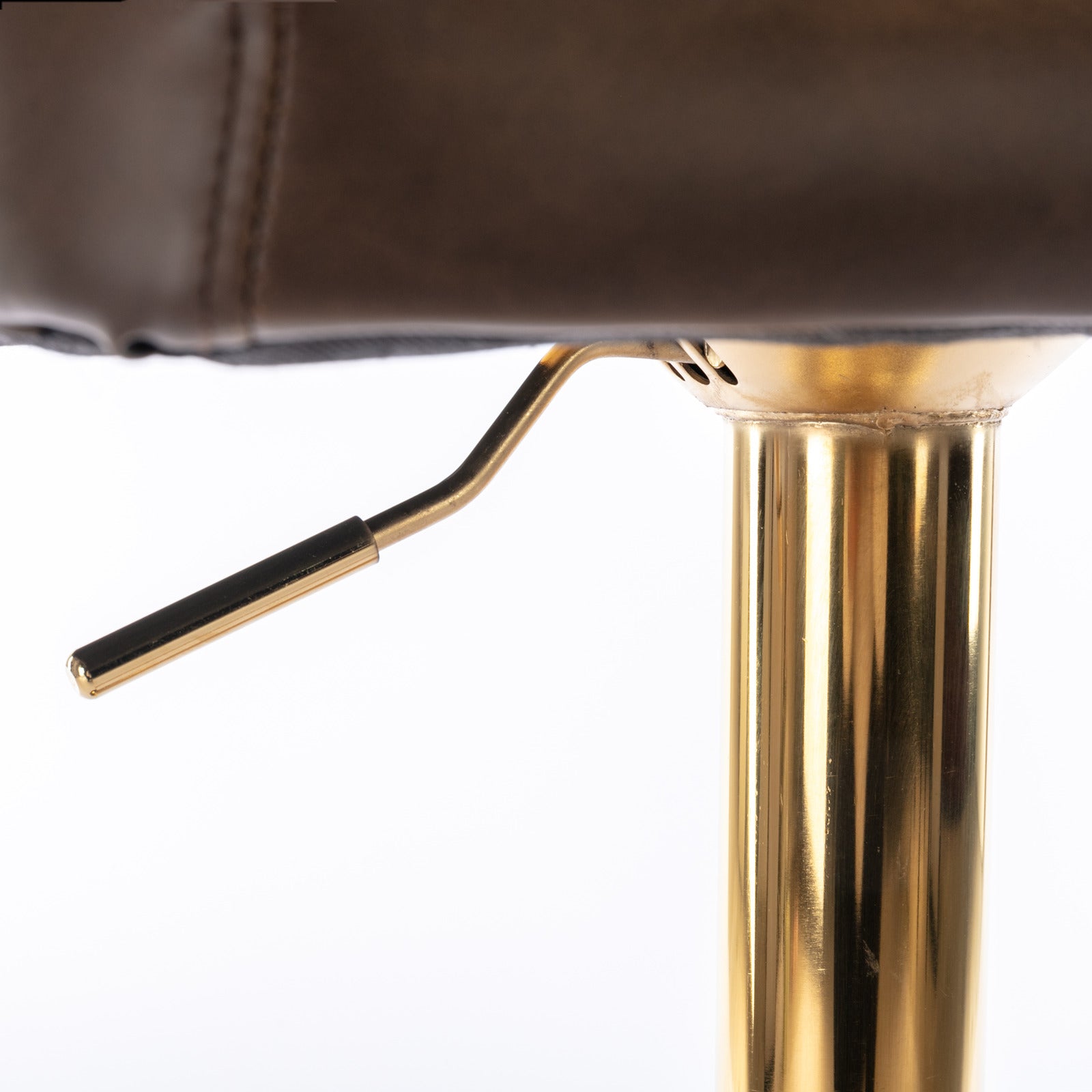 Brown leather seat detail on a gold adjustable stool with lever