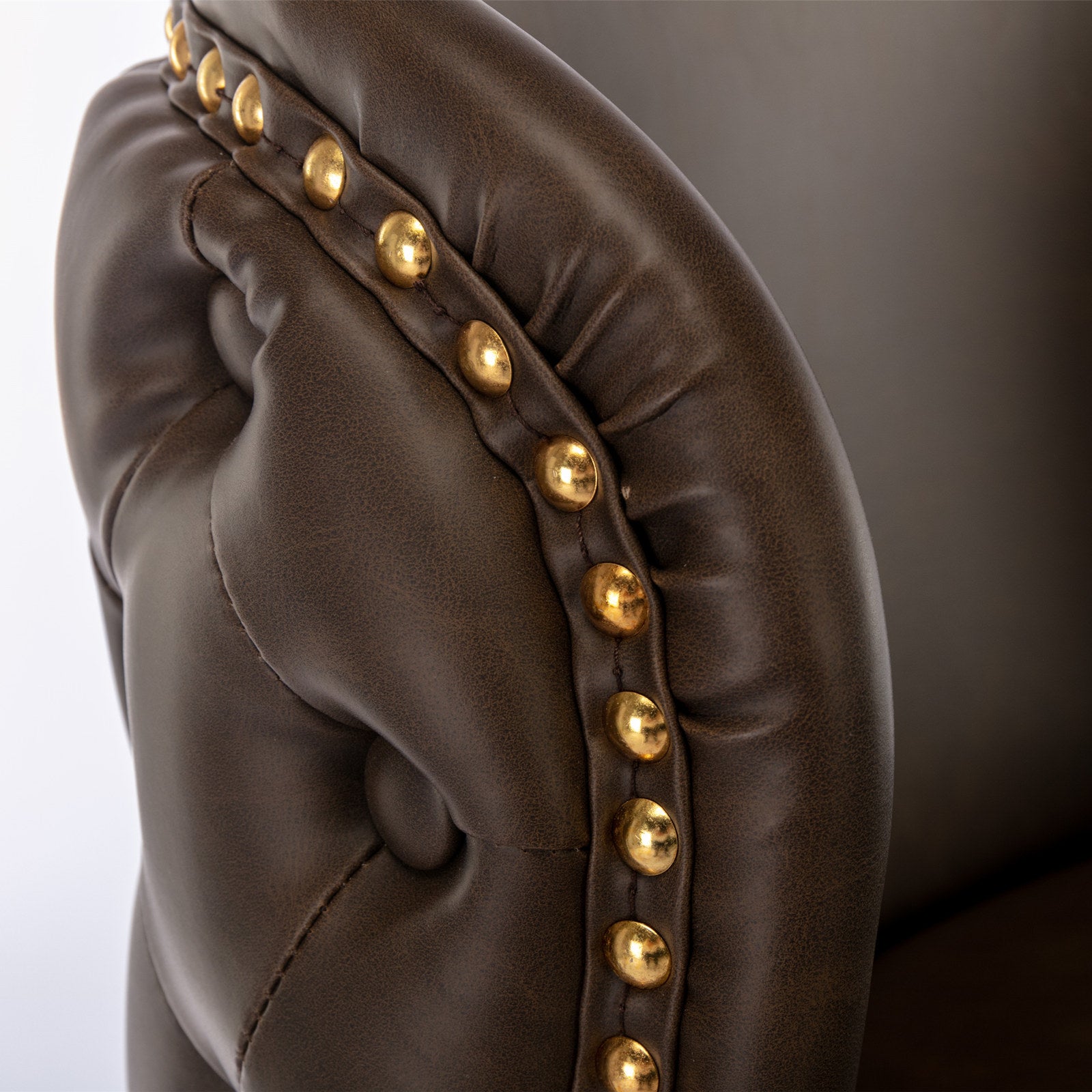 Tufted dark brown faux leather armchair accent with brass nailhead trim
