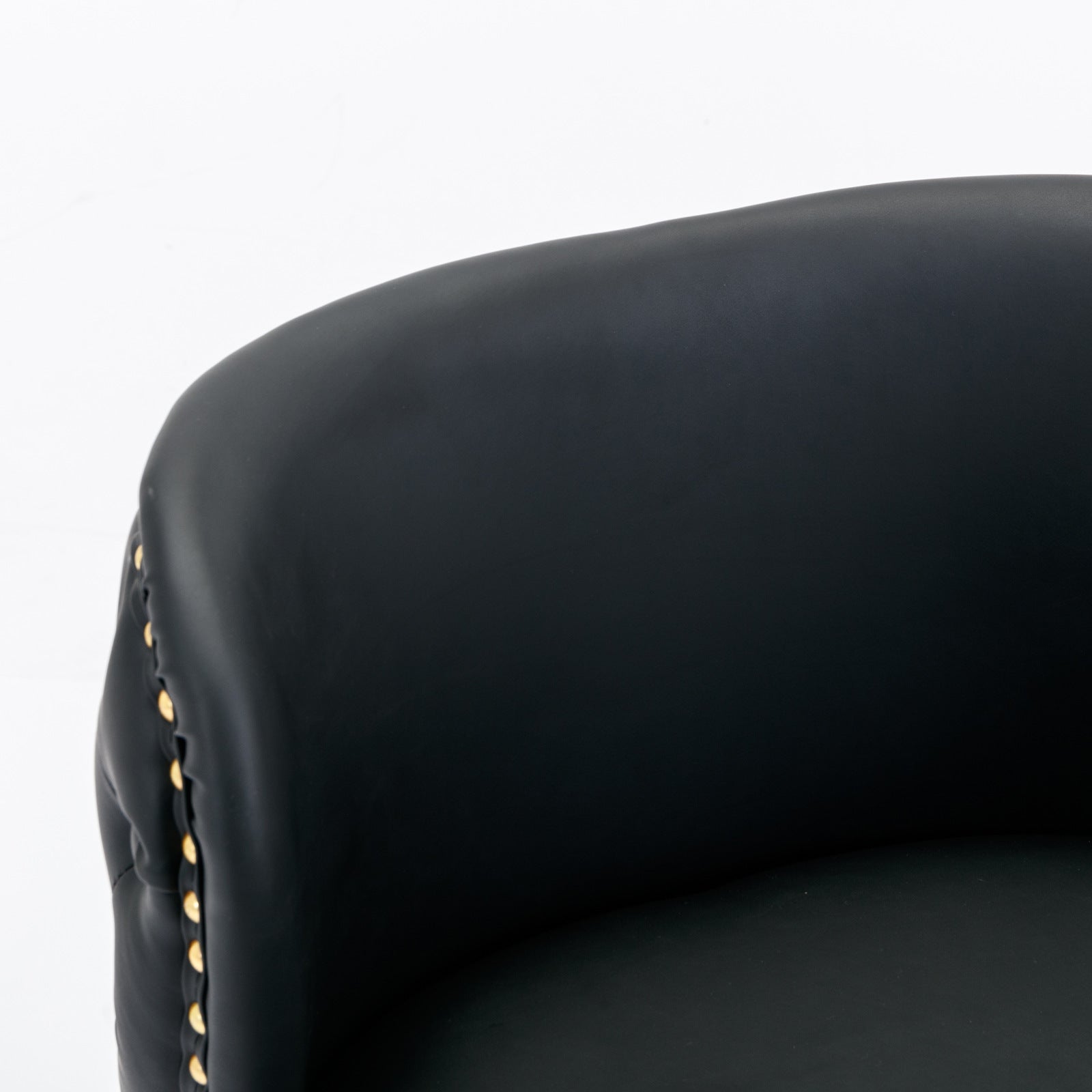 Black leather accent chair with decorative brass studs