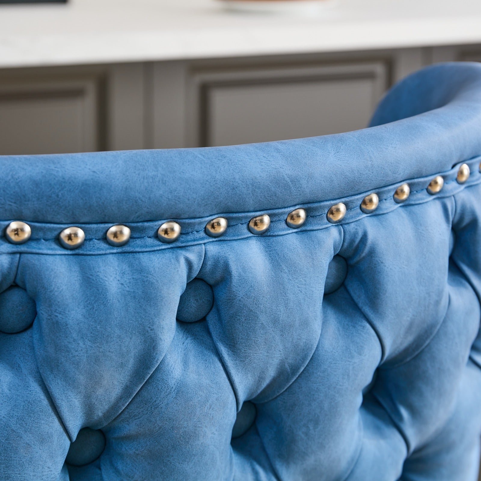 Blue velvet armchair with tufted back and polished brass nailhead trim