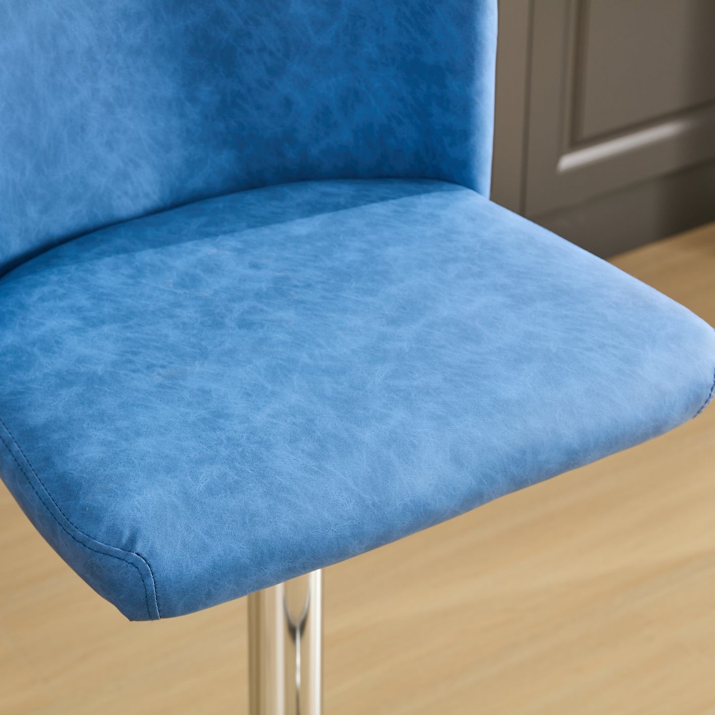 Closeup of a textured blue faux leather bar stool seat