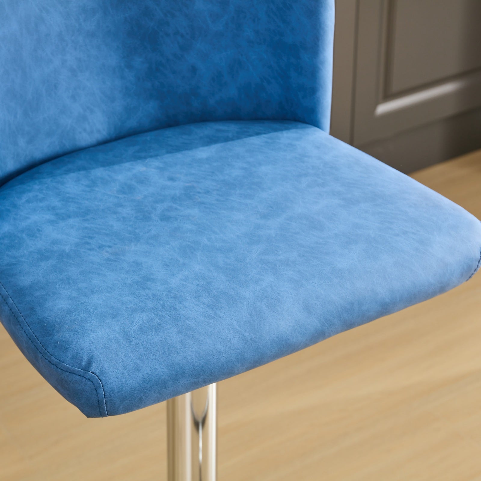 Closeup of a textured blue faux leather bar stool seat