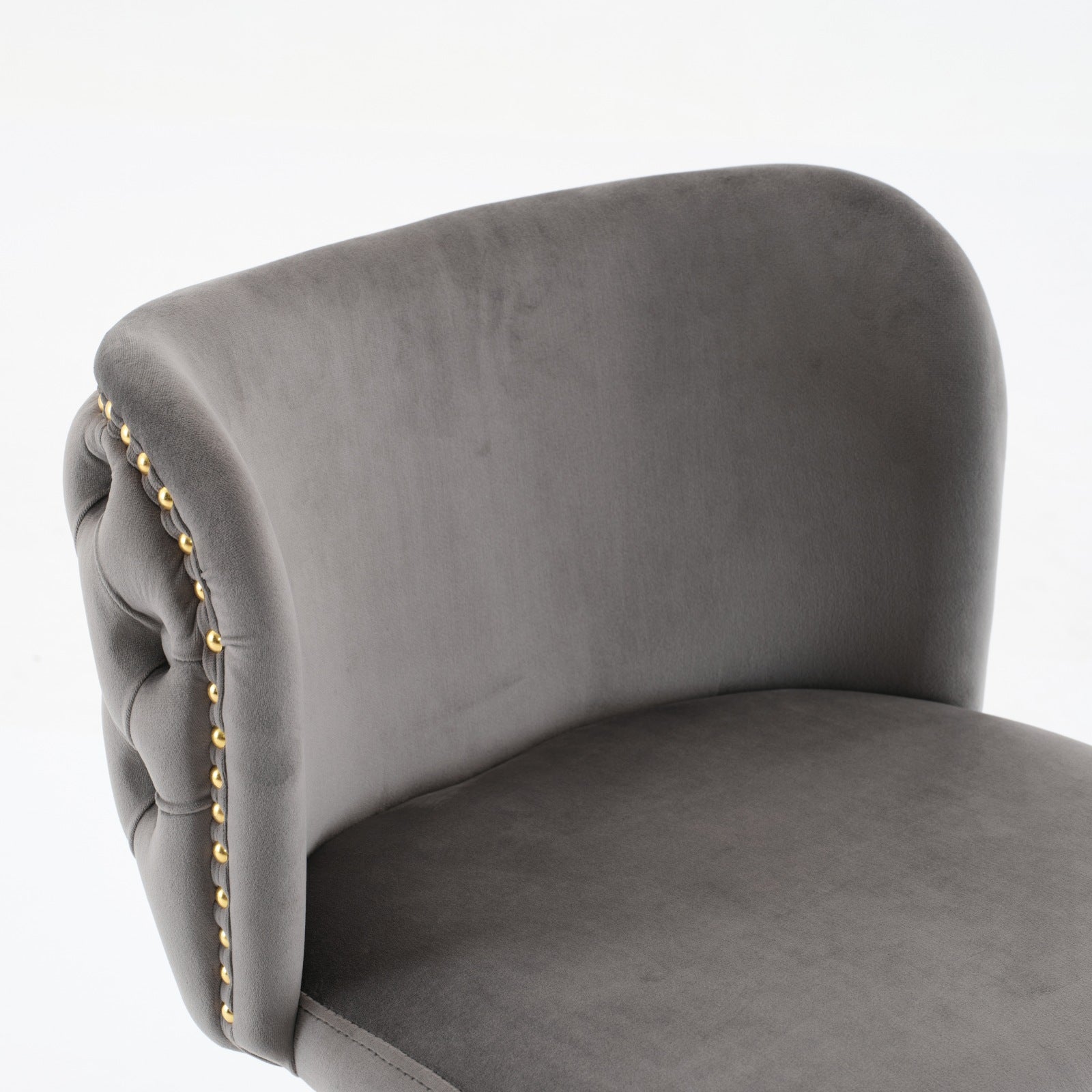 Grey velvet bar stool with tufted back and gold nailhead trim detail