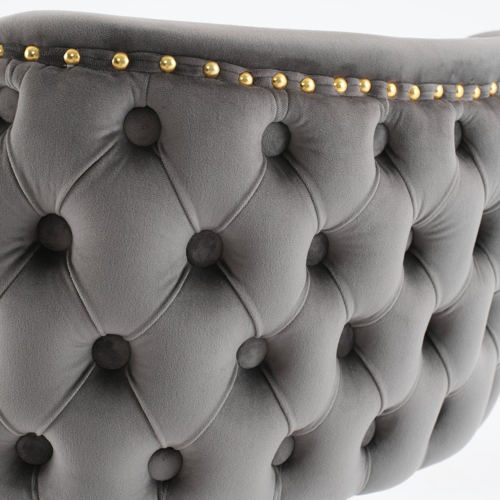 Grey velvet tufted armchair detail with brass nailhead trim