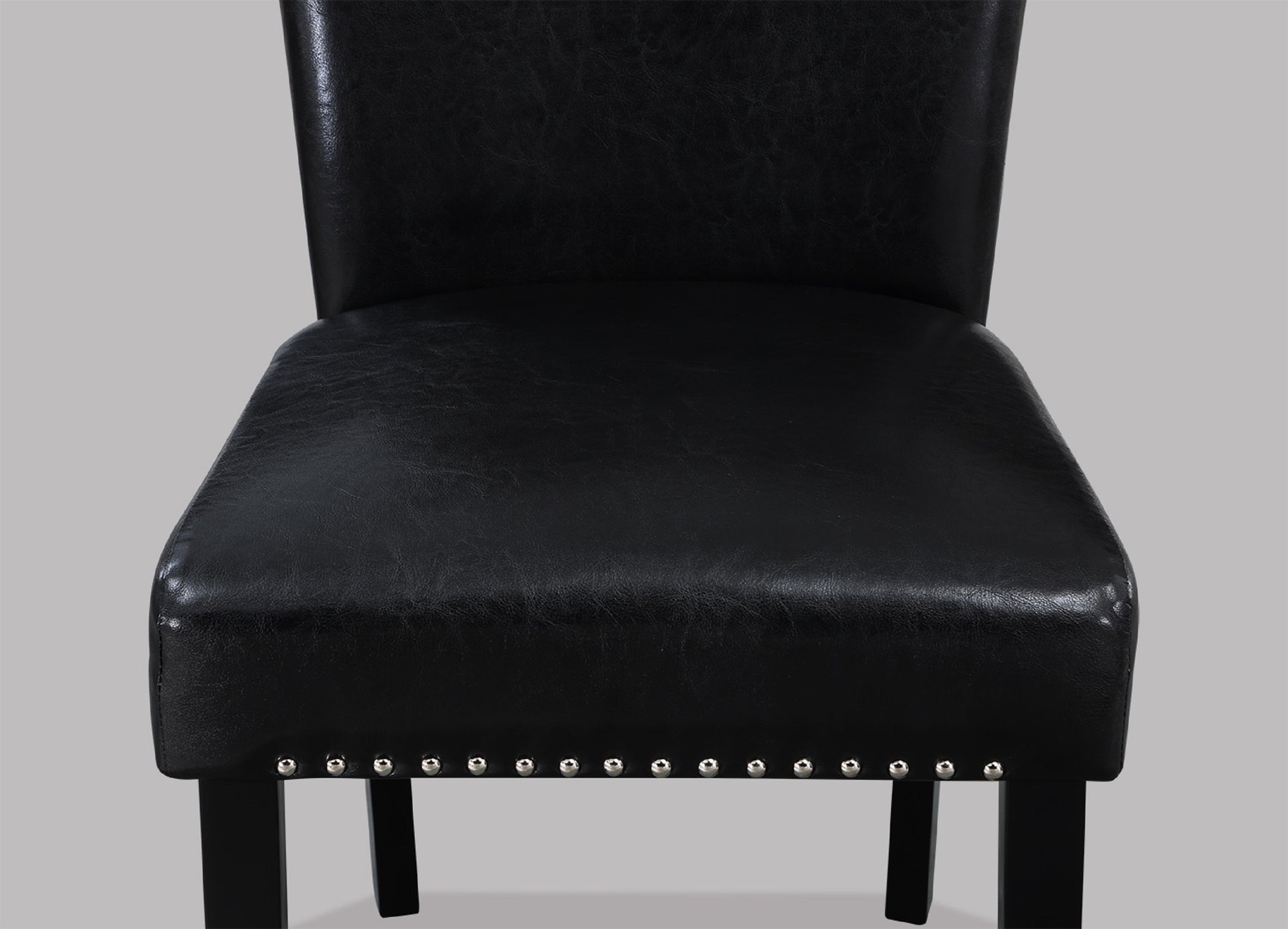 Black faux leather dining chair with silver nailhead trim and dark wood legs