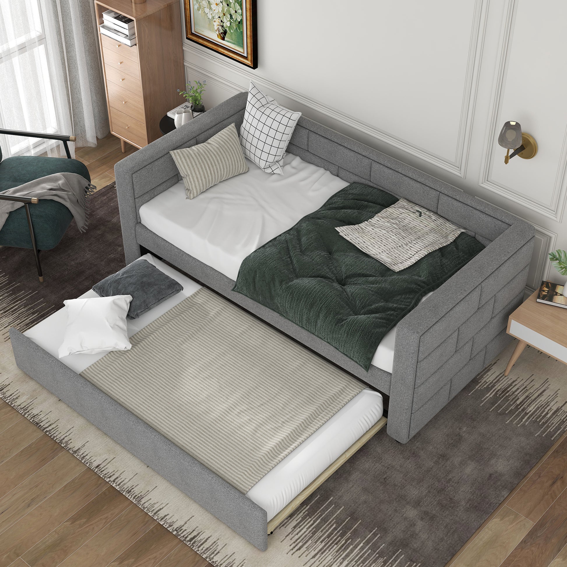 Grey fabric daybed with trundle featuring quilted green blanket and striped pillows