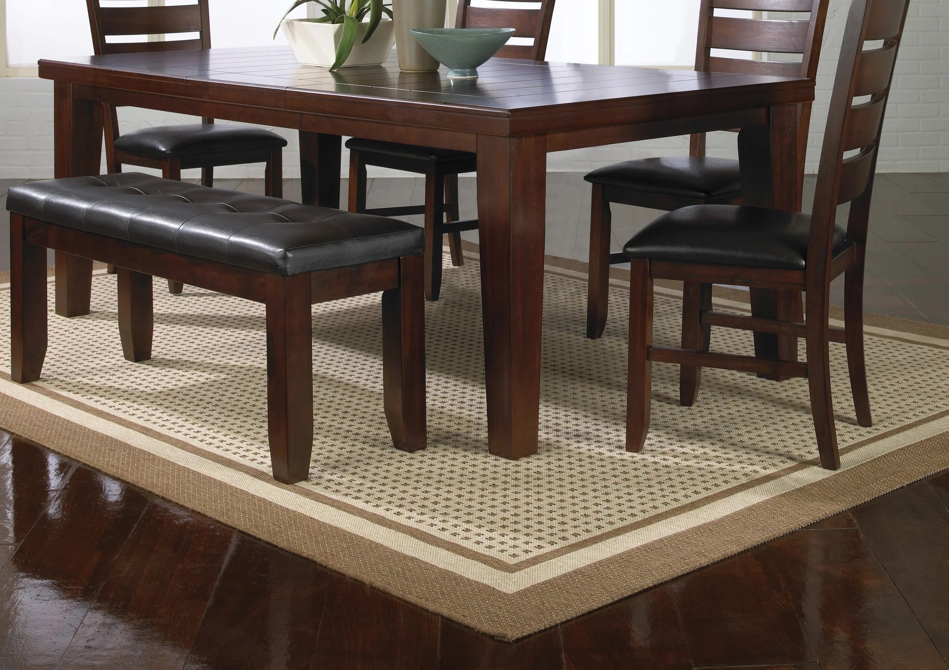 Dark wood dining table with four chairs and a tufted leather bench