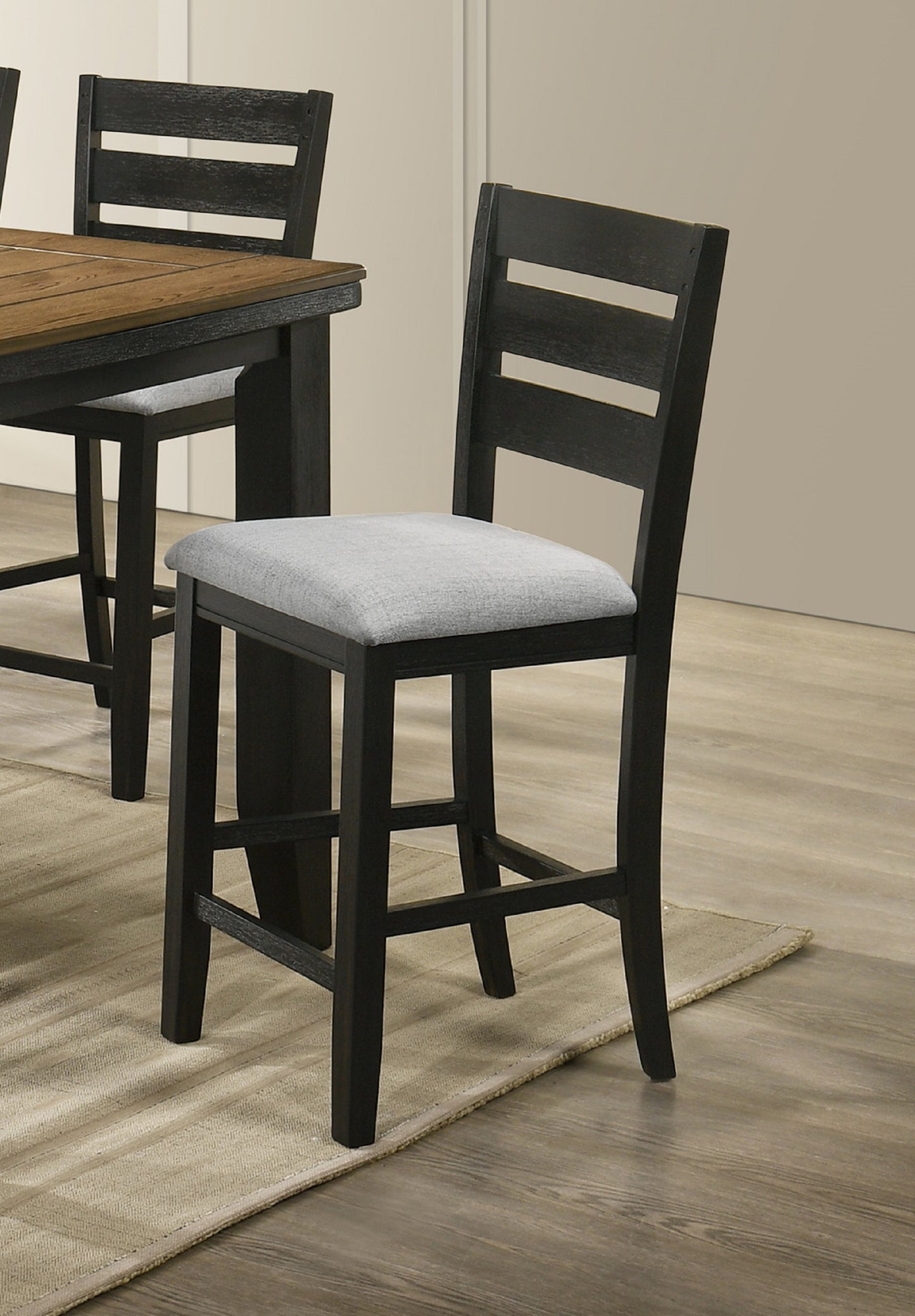 Black counter stool with gray cushioned seat and ladder back design