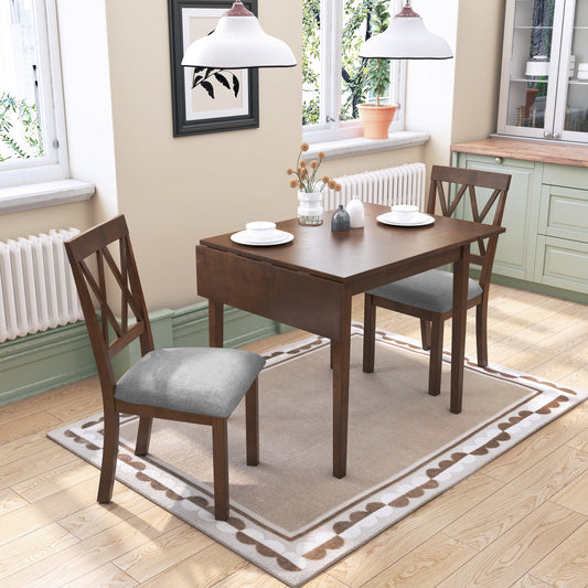Dark wood drop leaf dining table with gray upholstered chairs and white plates