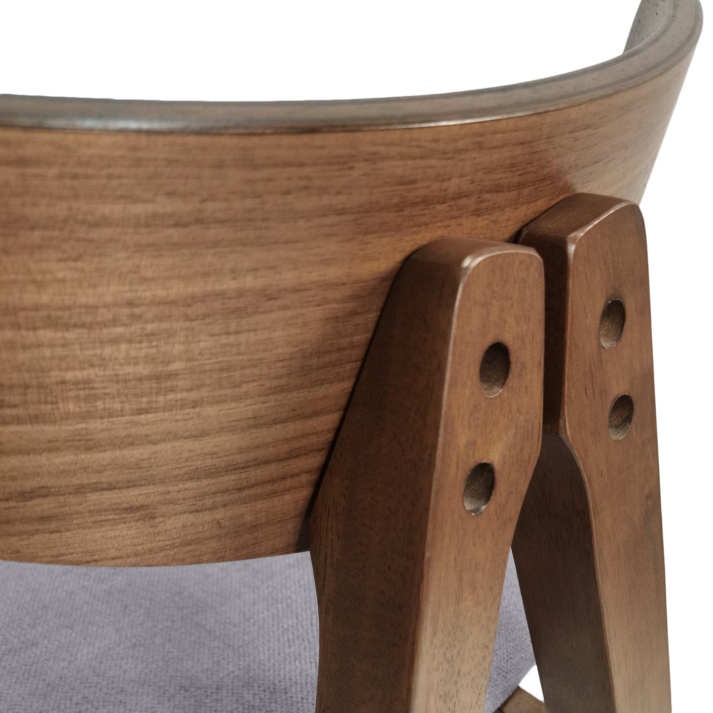 Closeup of curved walnut wood chair back with visible grain and grey fabric seat