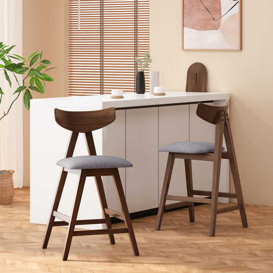 Two modern wood and gray fabric bar stools at a white kitchen island
