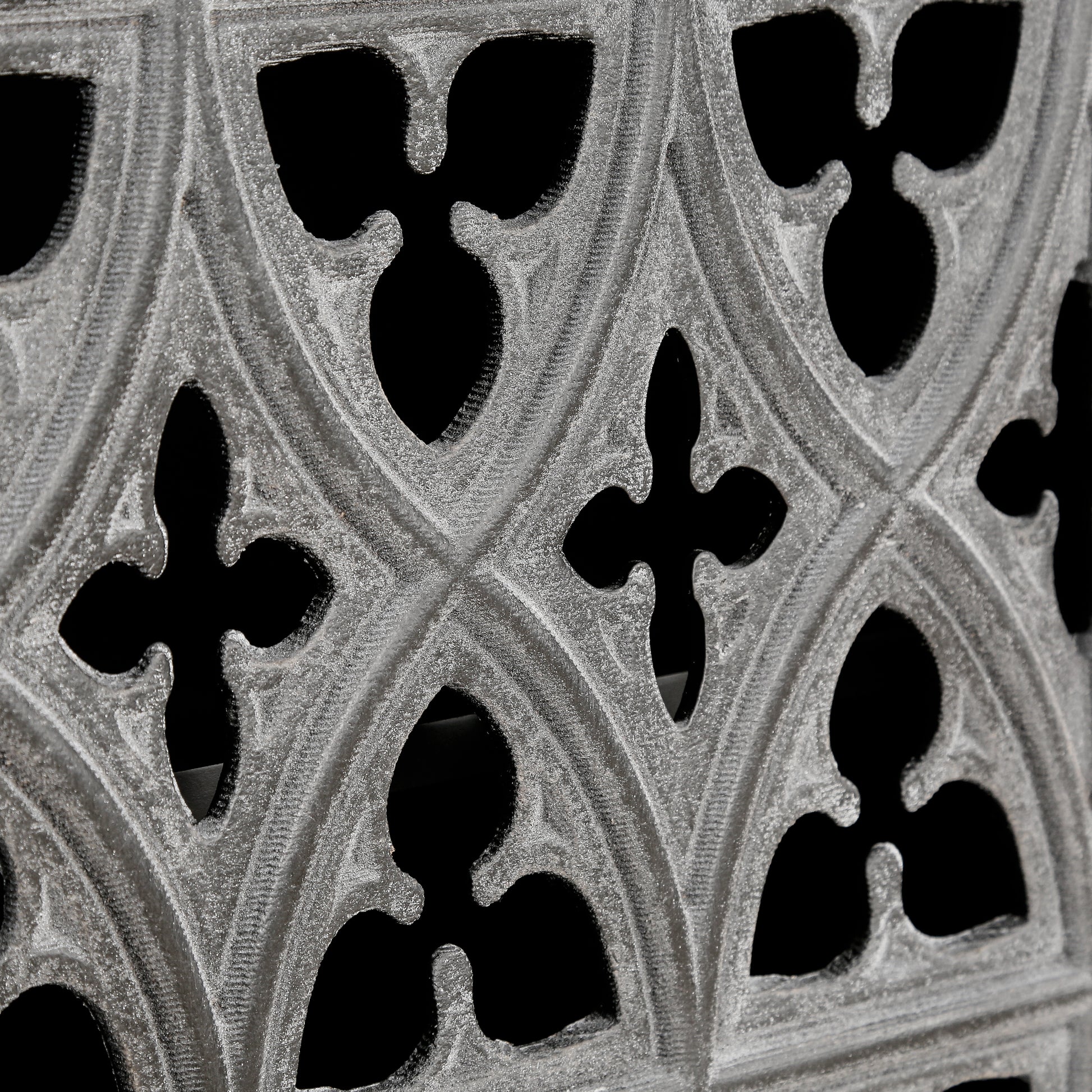 Textured grey ornate decorative screen with gothic tracery