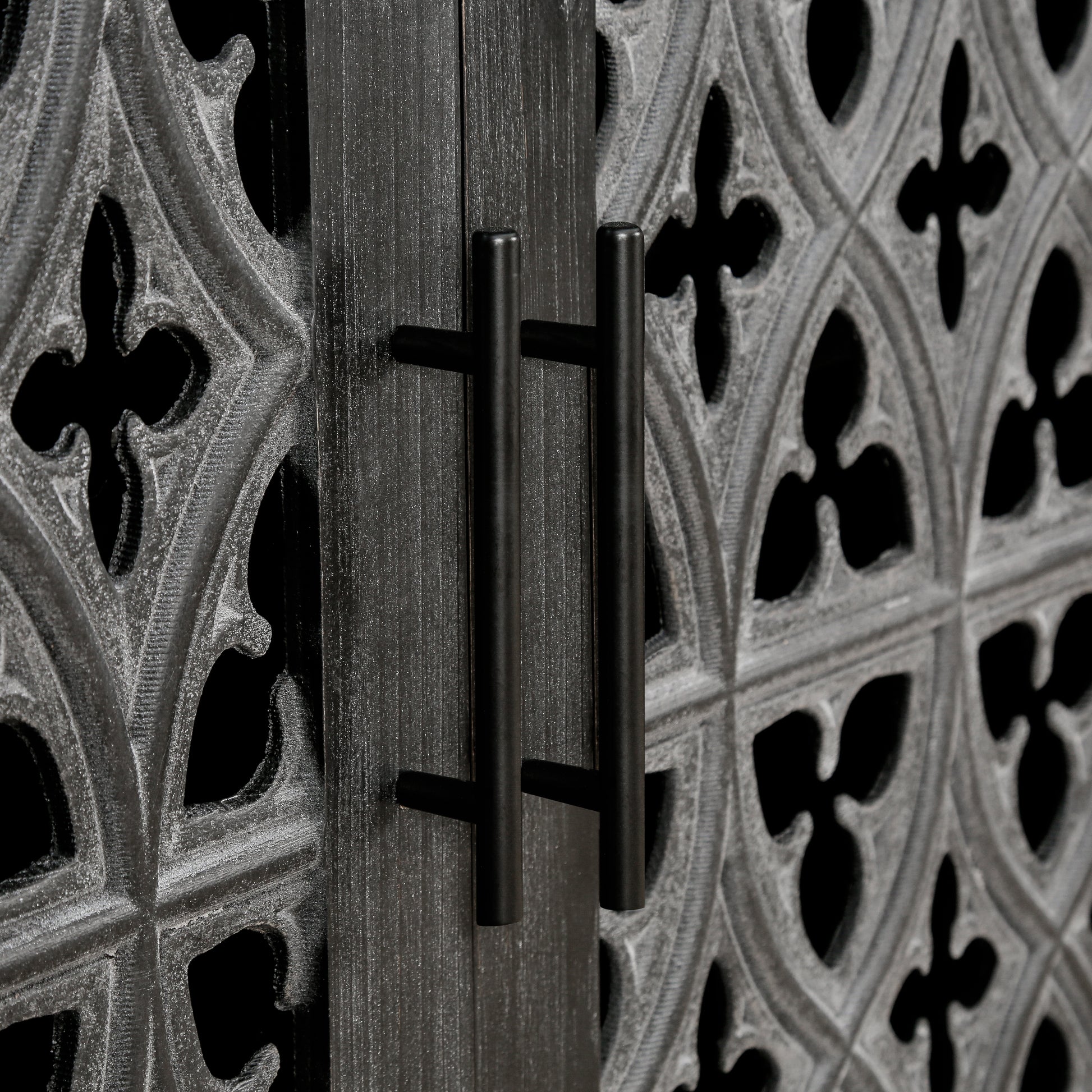 Black modern cabinet doors with ornate gothic carvings and sleek bar handles