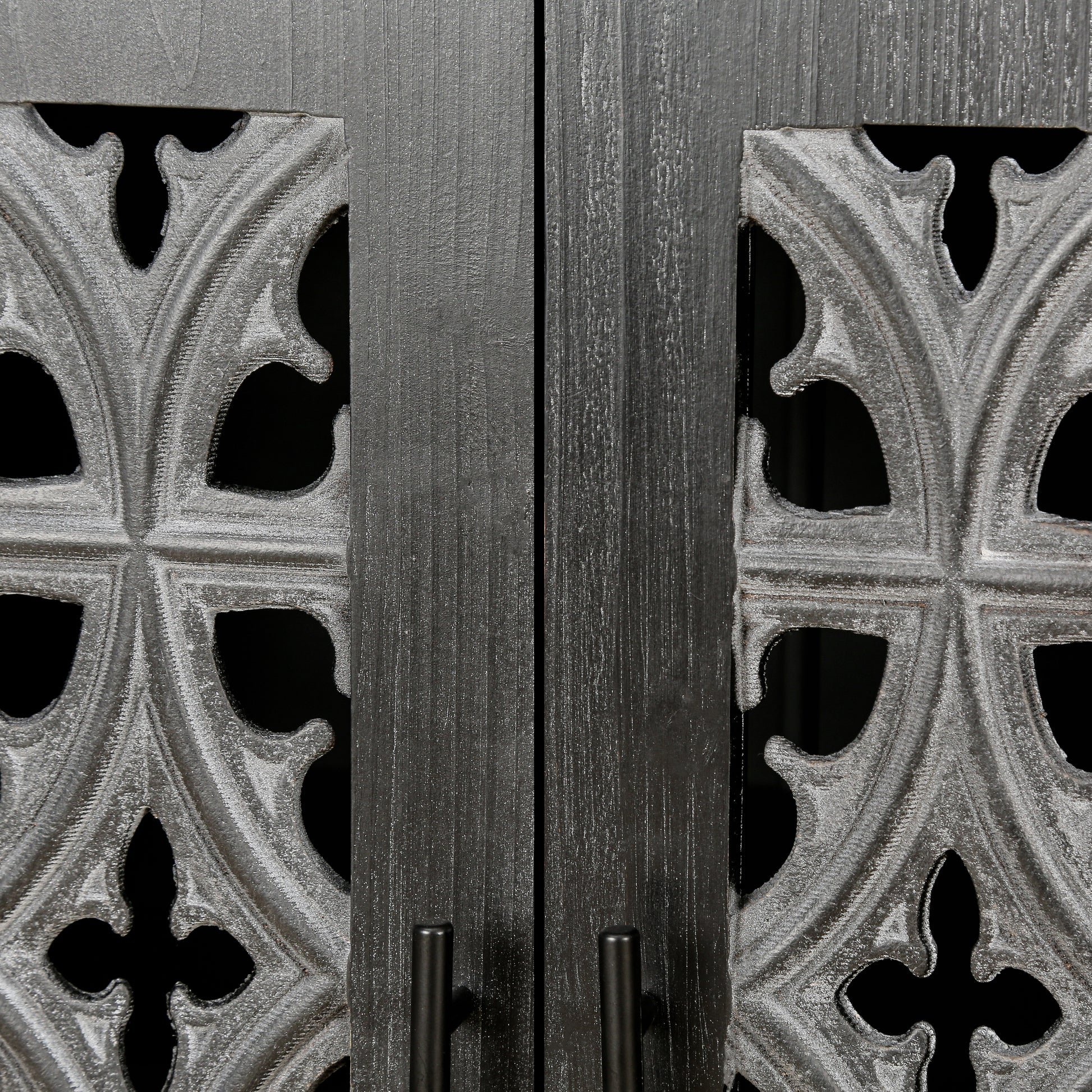 Close up of dark grey wooden cabinet doors with ornate gothicstyle metal grilles