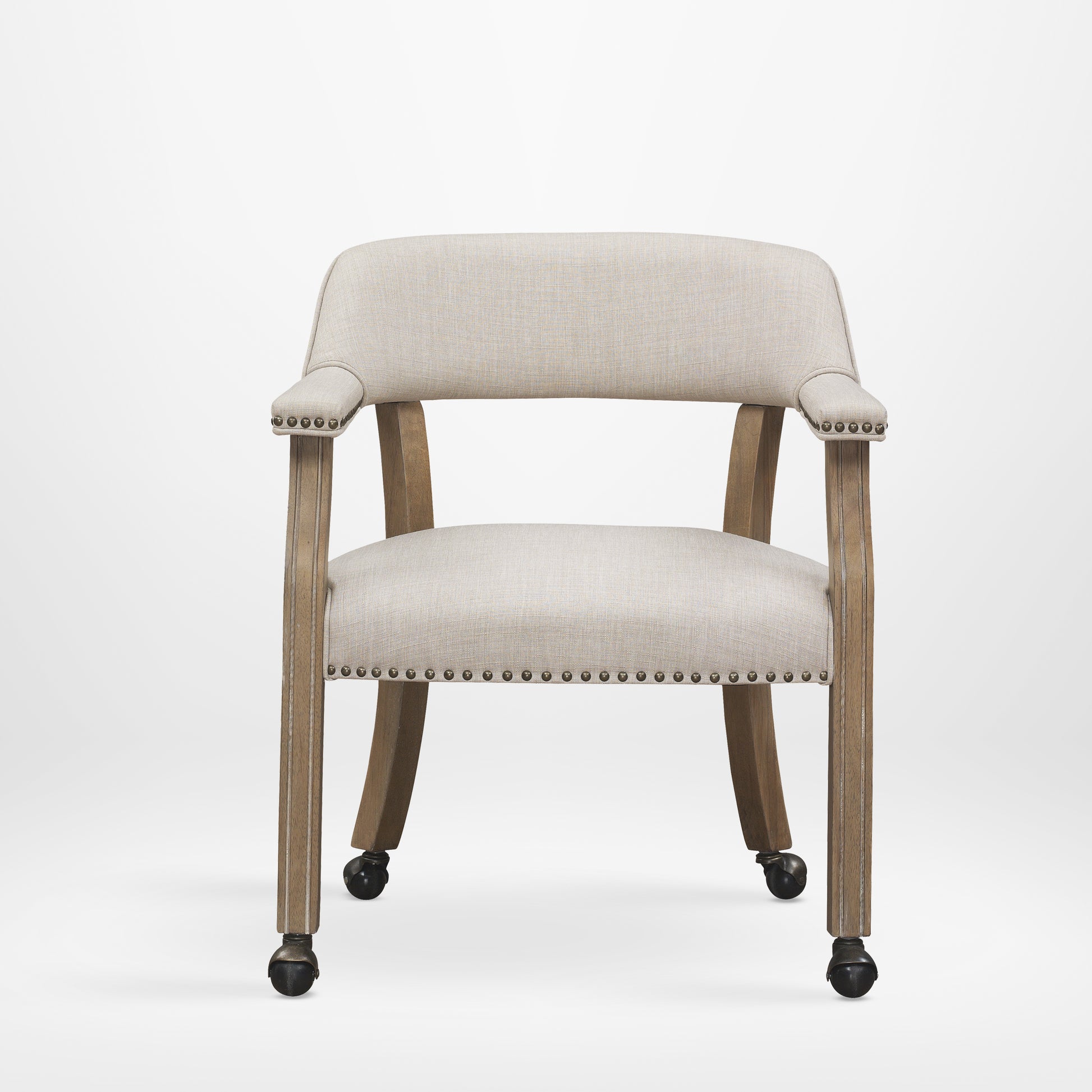 Beige upholstered armchair with antique brass nailhead trim and casters