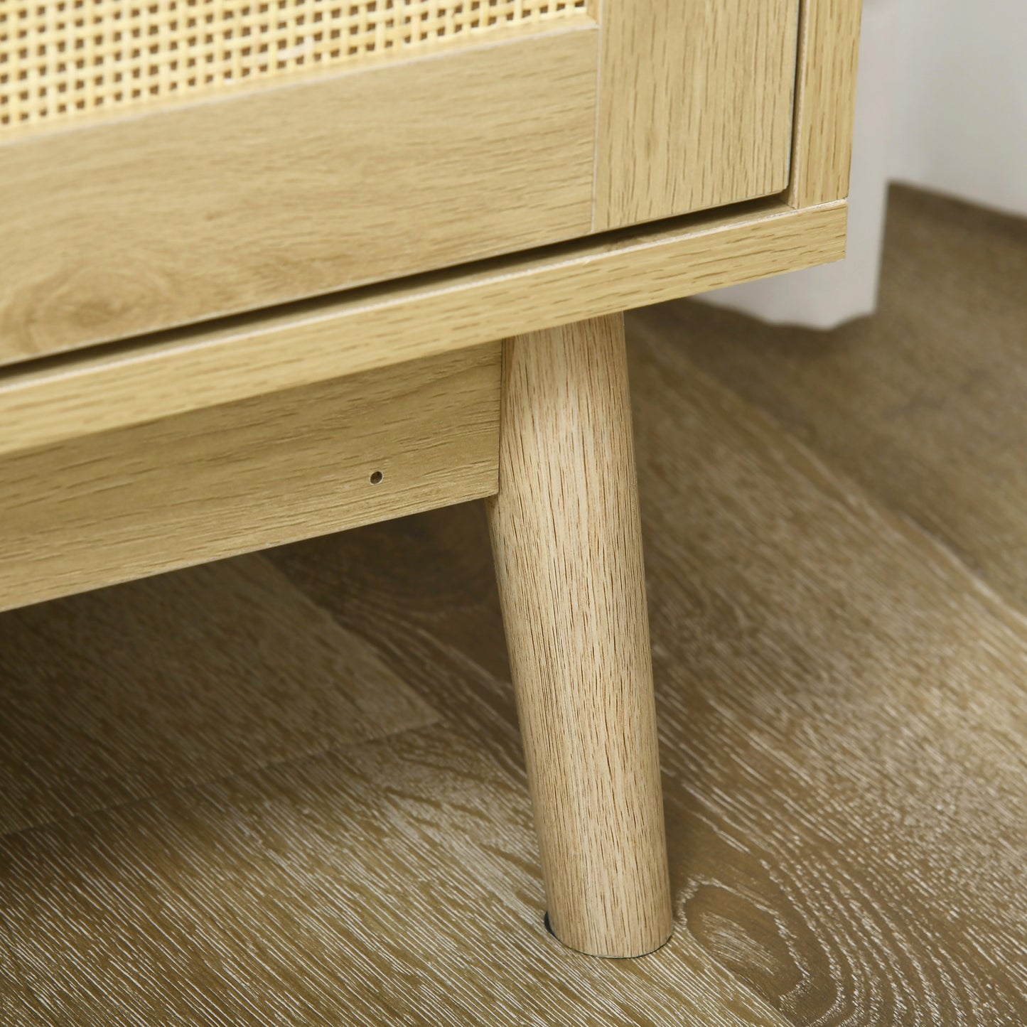 Light oak wood cabinet leg on textured floor