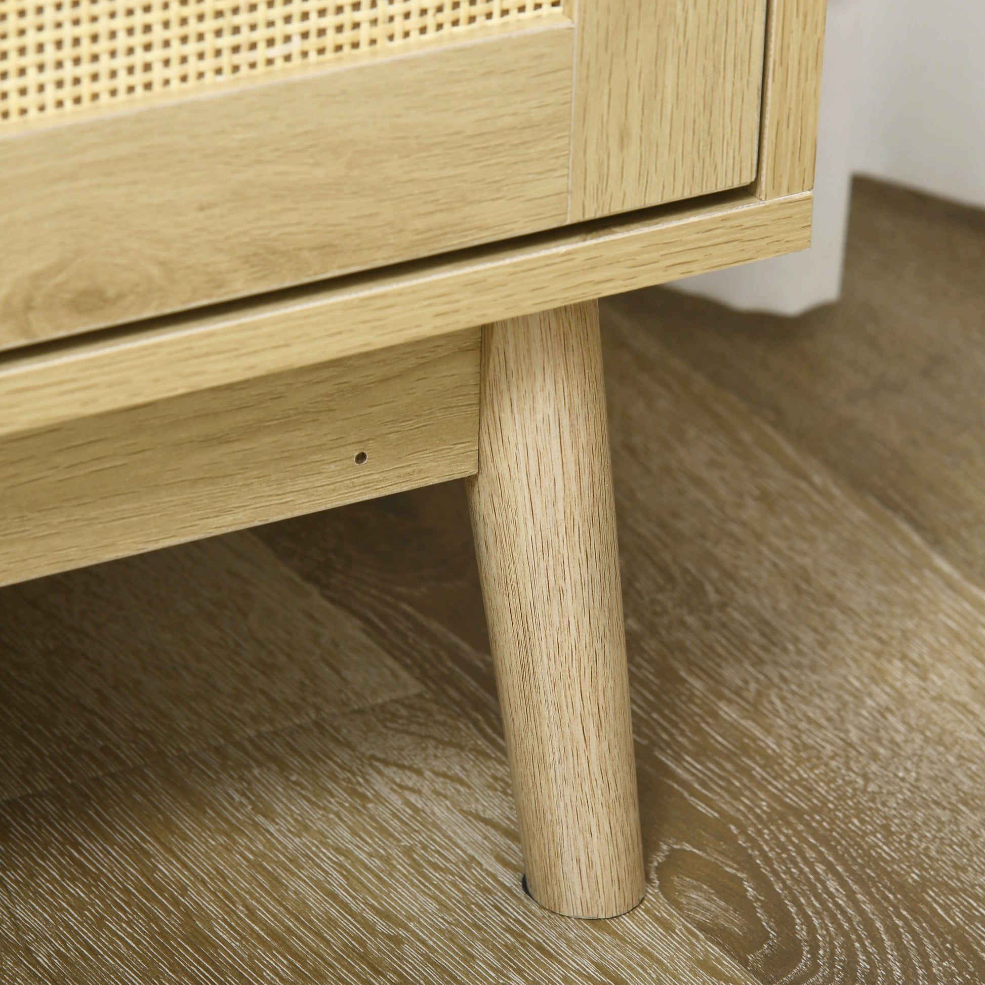 Light oak wood cabinet leg on textured floor