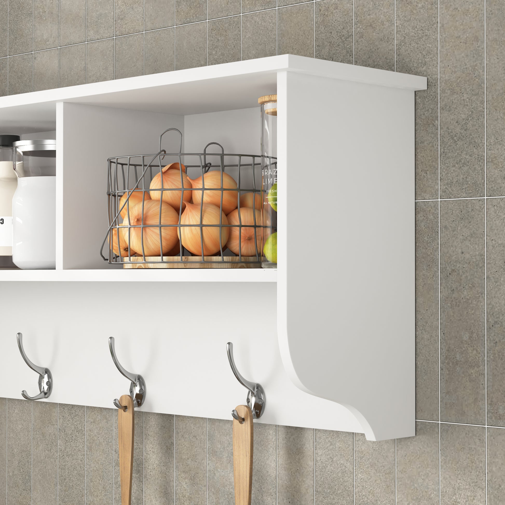 White wall mounted shelf with three chrome hooks holding wooden utensils