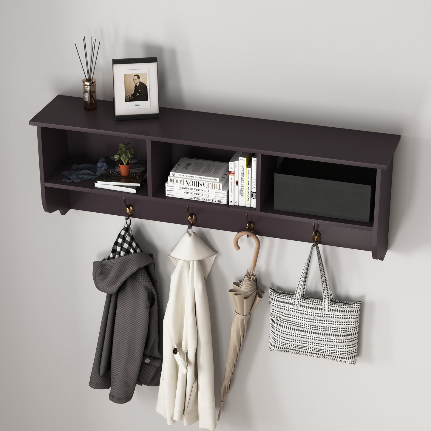 Dark wood coat rack with hooks holding a checkered jacket cream coat beige umbrella and tote bag