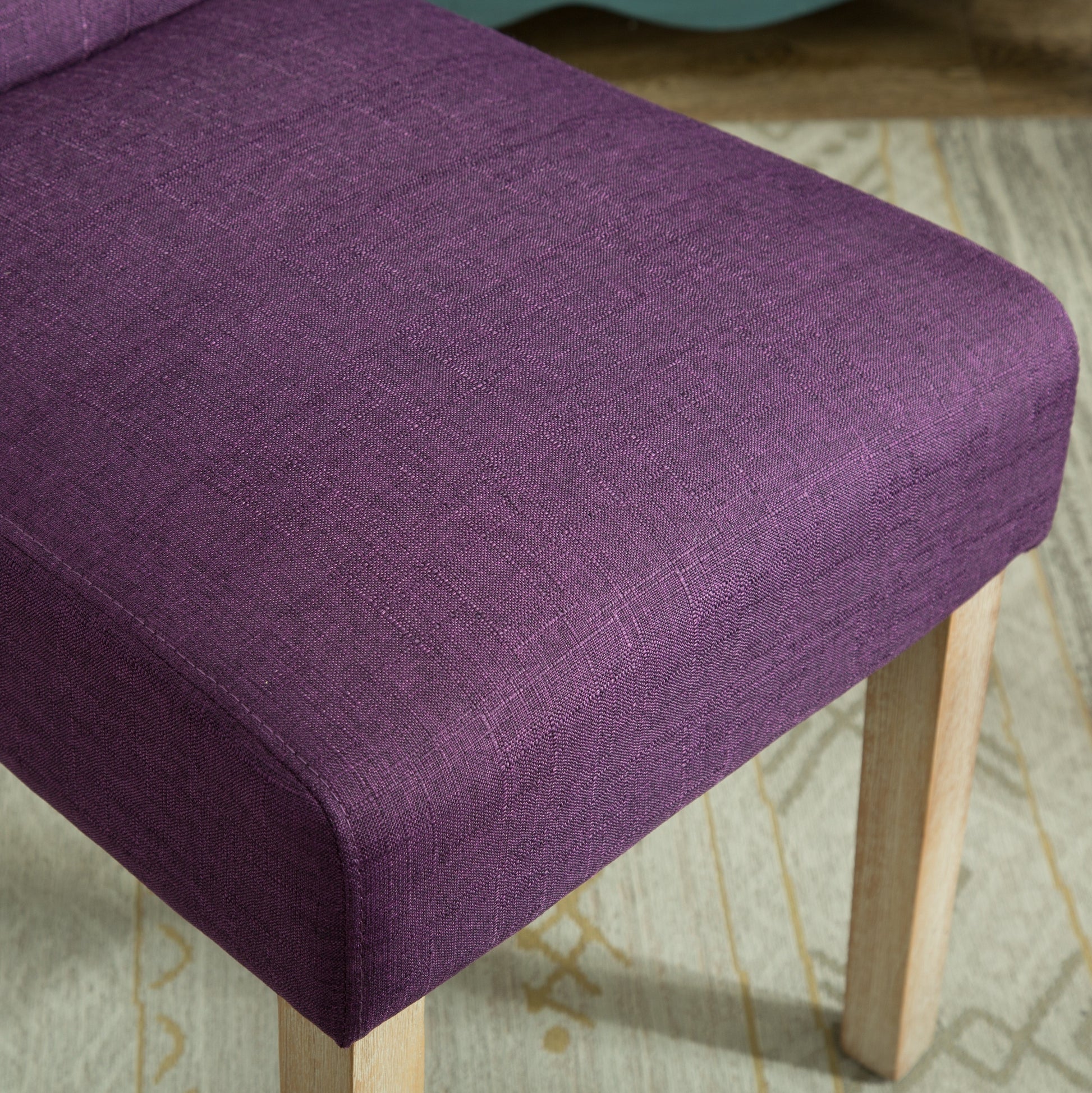 Closeup of rich purple linen fabric on an upholstered chair seat