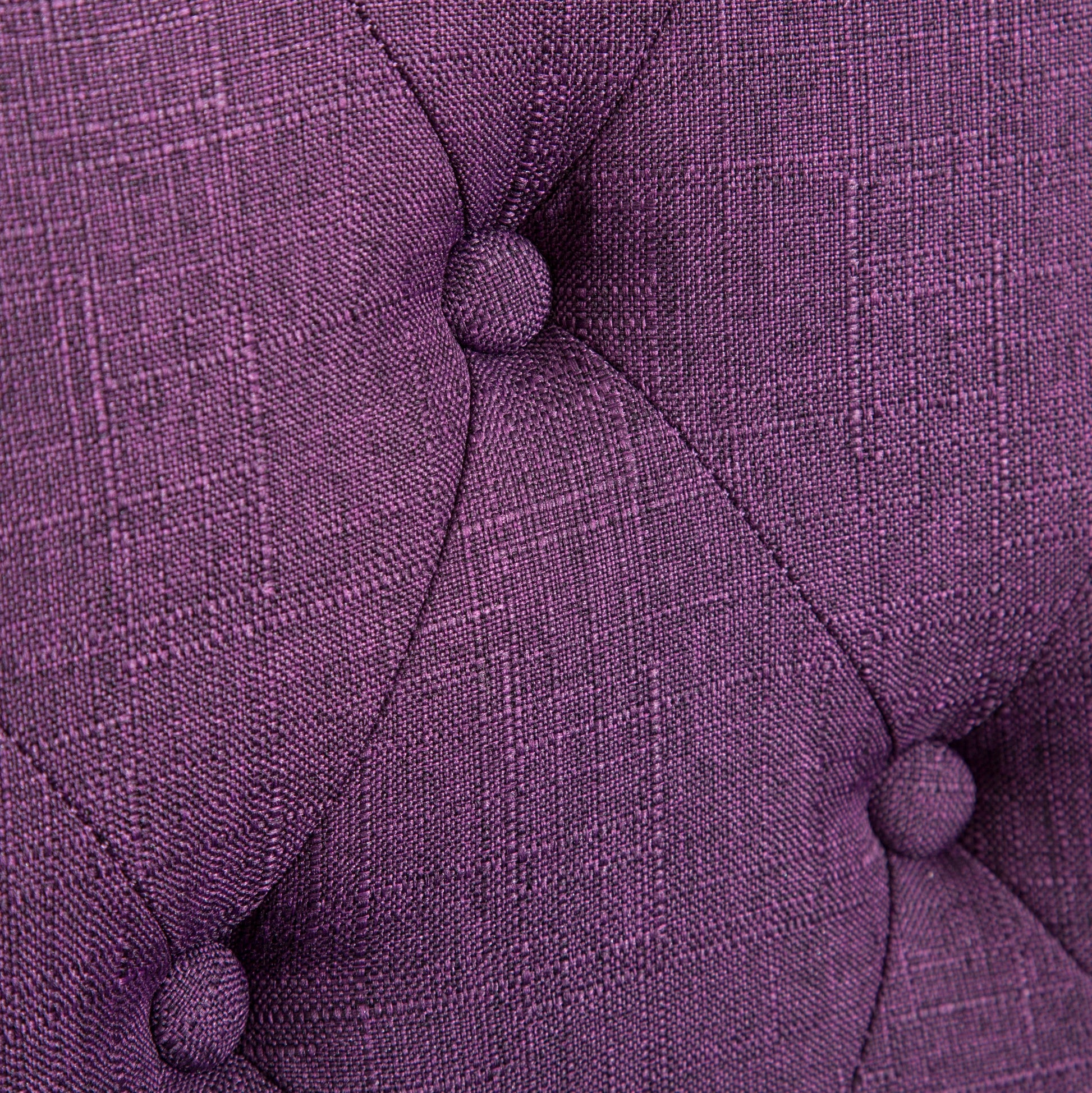 Deep purple upholstered fabric with diamond tufting and button accents