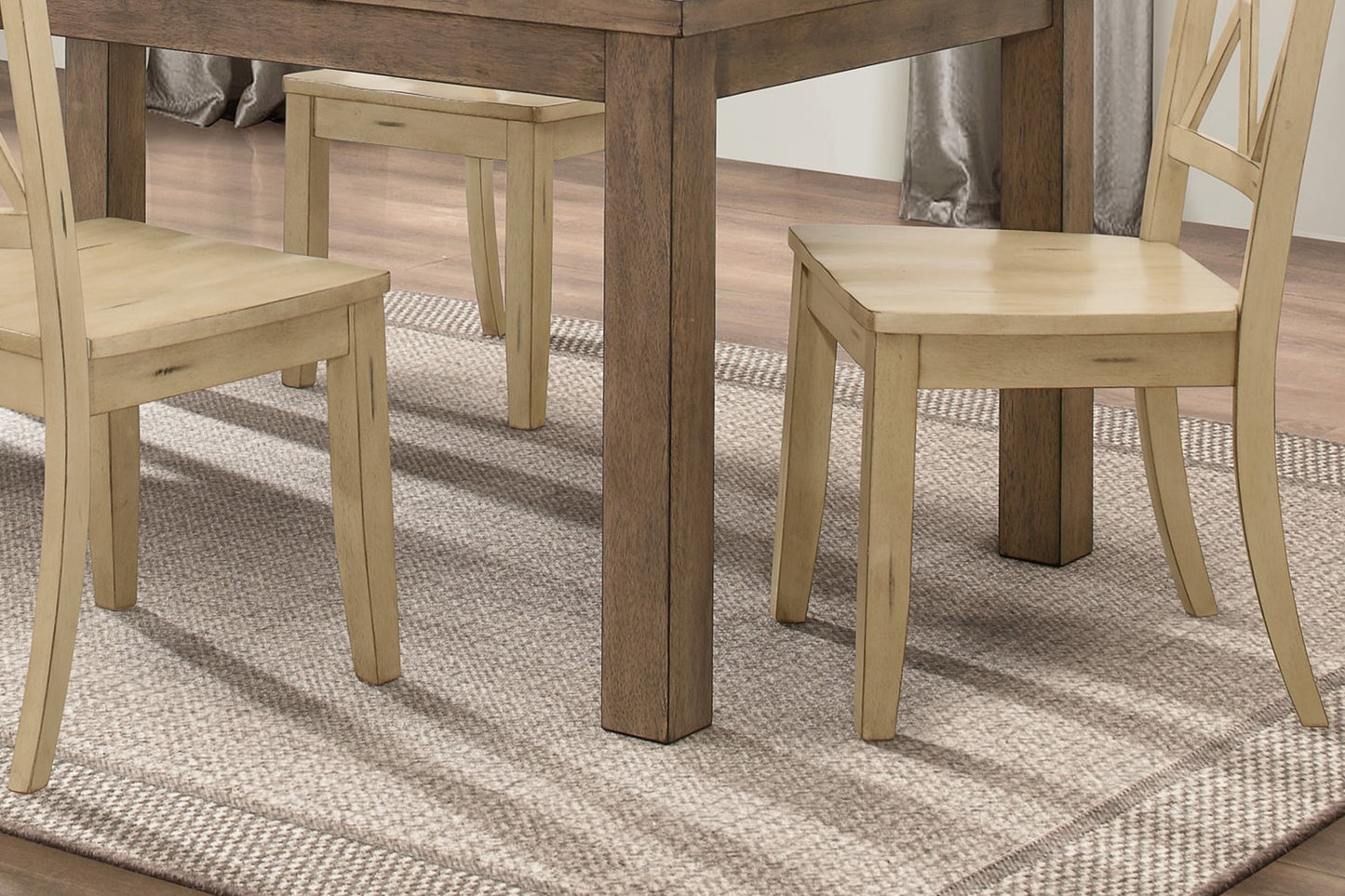 Light wood farmhouse dining chair with distressed finish on textured rug