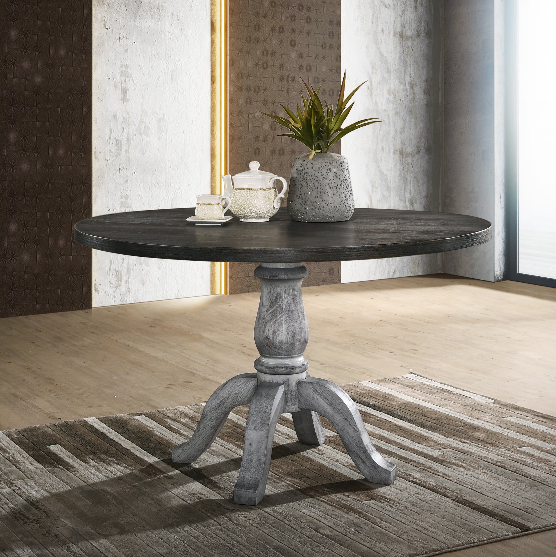 Round dark wood dining table with pedestal base and distressed finish