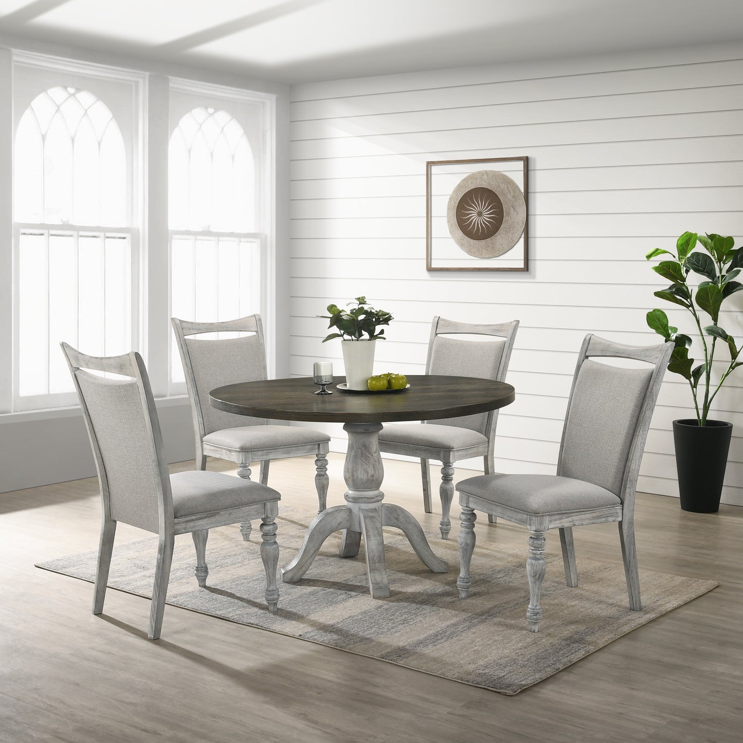 Round wood dining table with pedestal base and four upholstered chairs