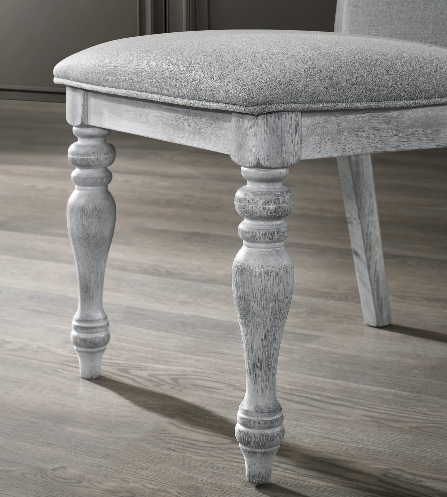 Light grey fabric upholstered dining chair with distressed wood legs