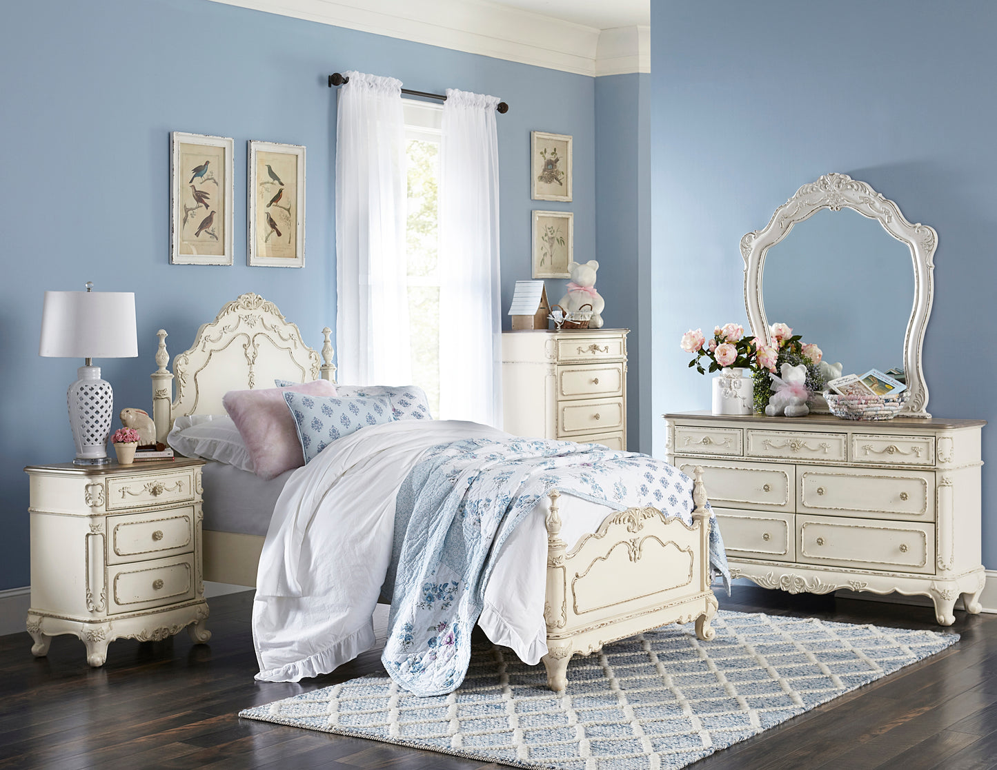 Antique white wooden bed frame with ornate detailing and blue floral bedding