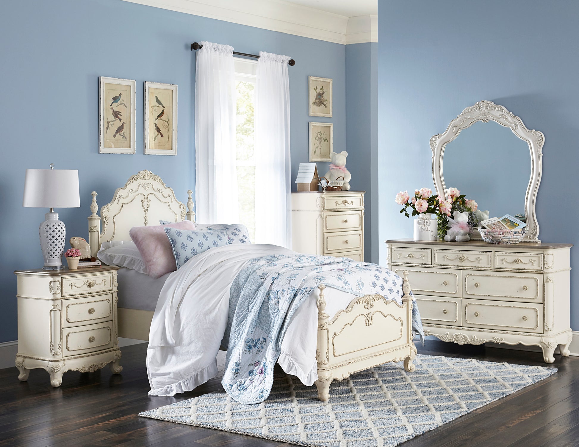 Antique white wooden bed frame with ornate detailing and blue floral bedding