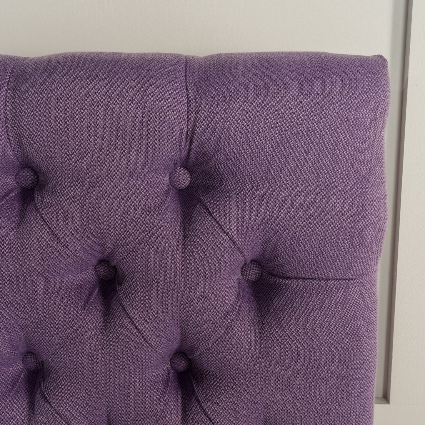 Purple tufted fabric headboard with diamond pattern stitching